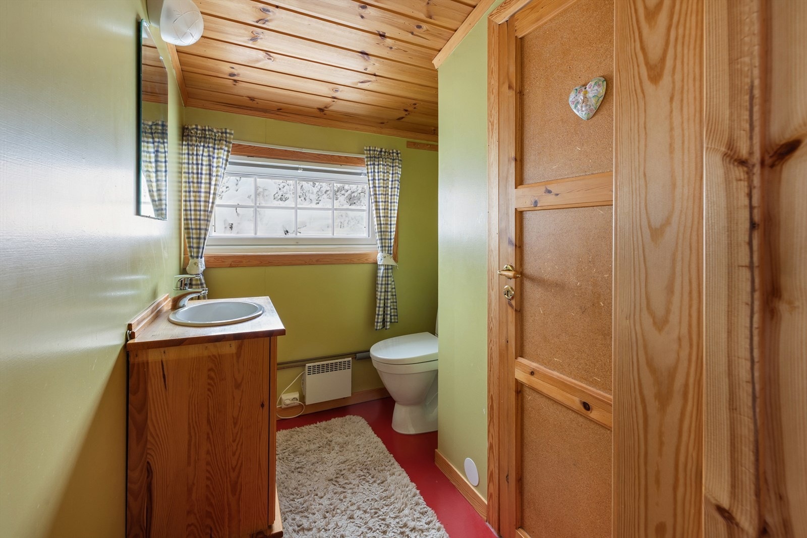 Toalettrommet har vinylbelegg på gulv og vegger. Rommet er innredet med servant med underskap og gulvmontert toalett. Galleribilde