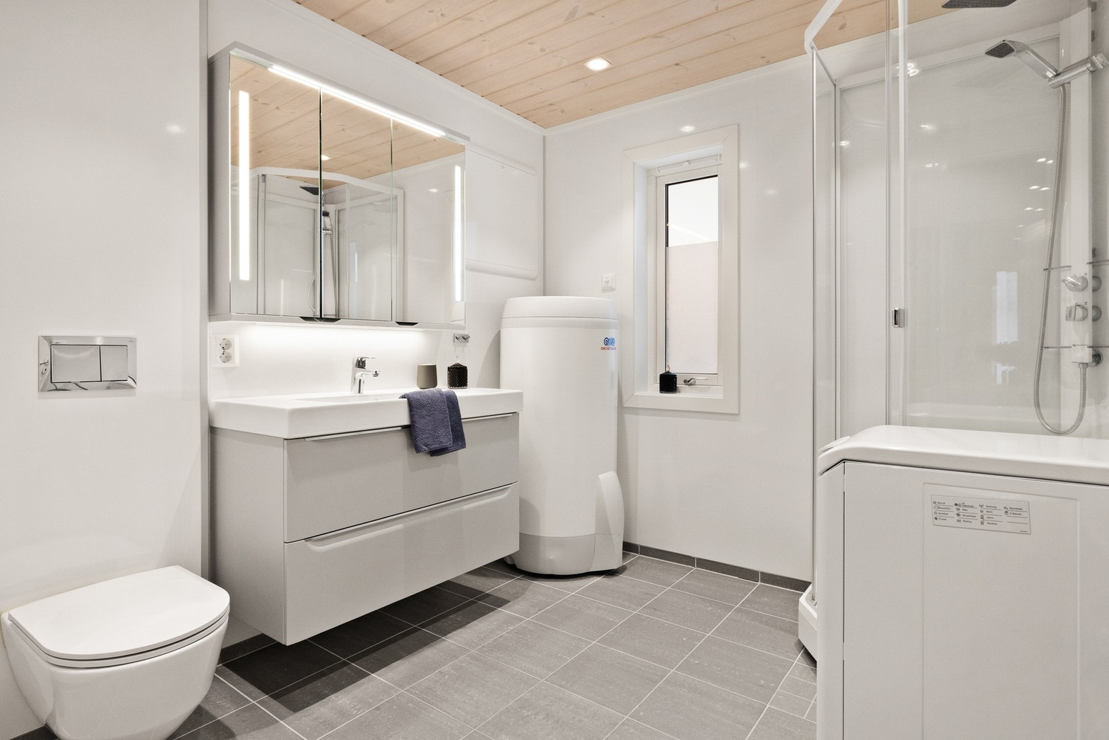 Flott baderom med flislagt gulv og termostatstyrt gulvvarme Galleribilde