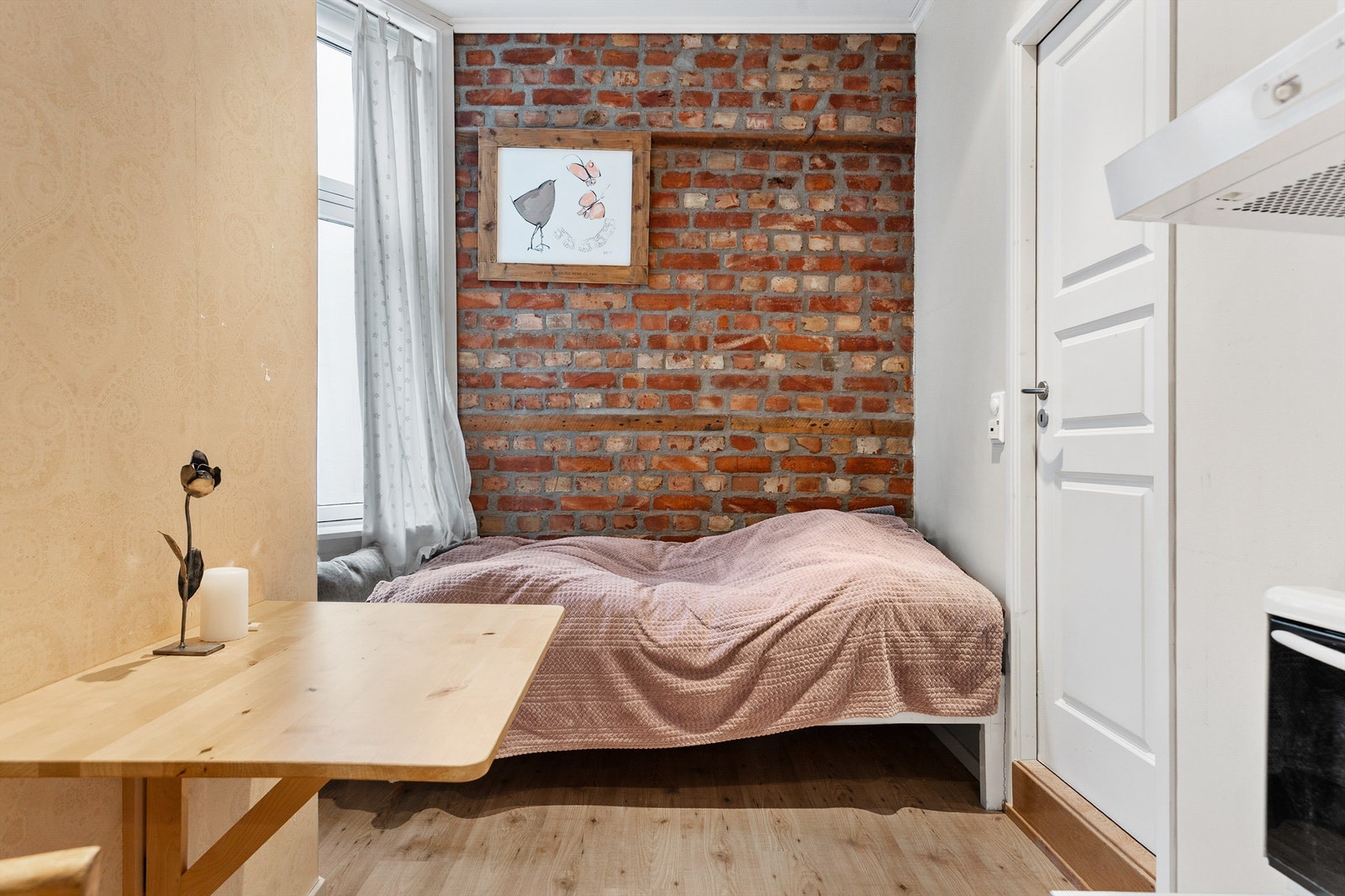 I hybeldelen er det plass til et lite spisebord samt sofa/seng i enden av rommet. Døren til høyre går inn til badet i hybelen. Galleribilde