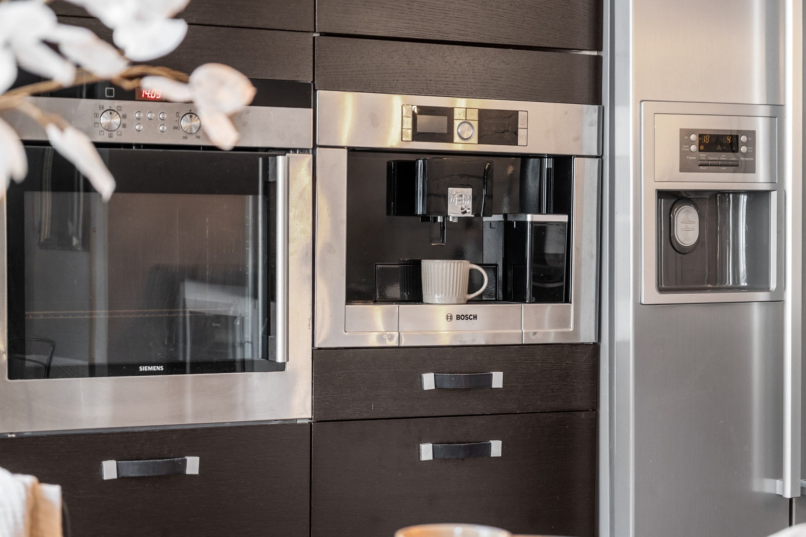 Benkeskapsbelysning og stikkontakter over kjøkkenbenk. Integrert stekeovn, platetopp, oppvaskmaskin, kaffemaskin og kjøleskap med fryser. Galleribilde