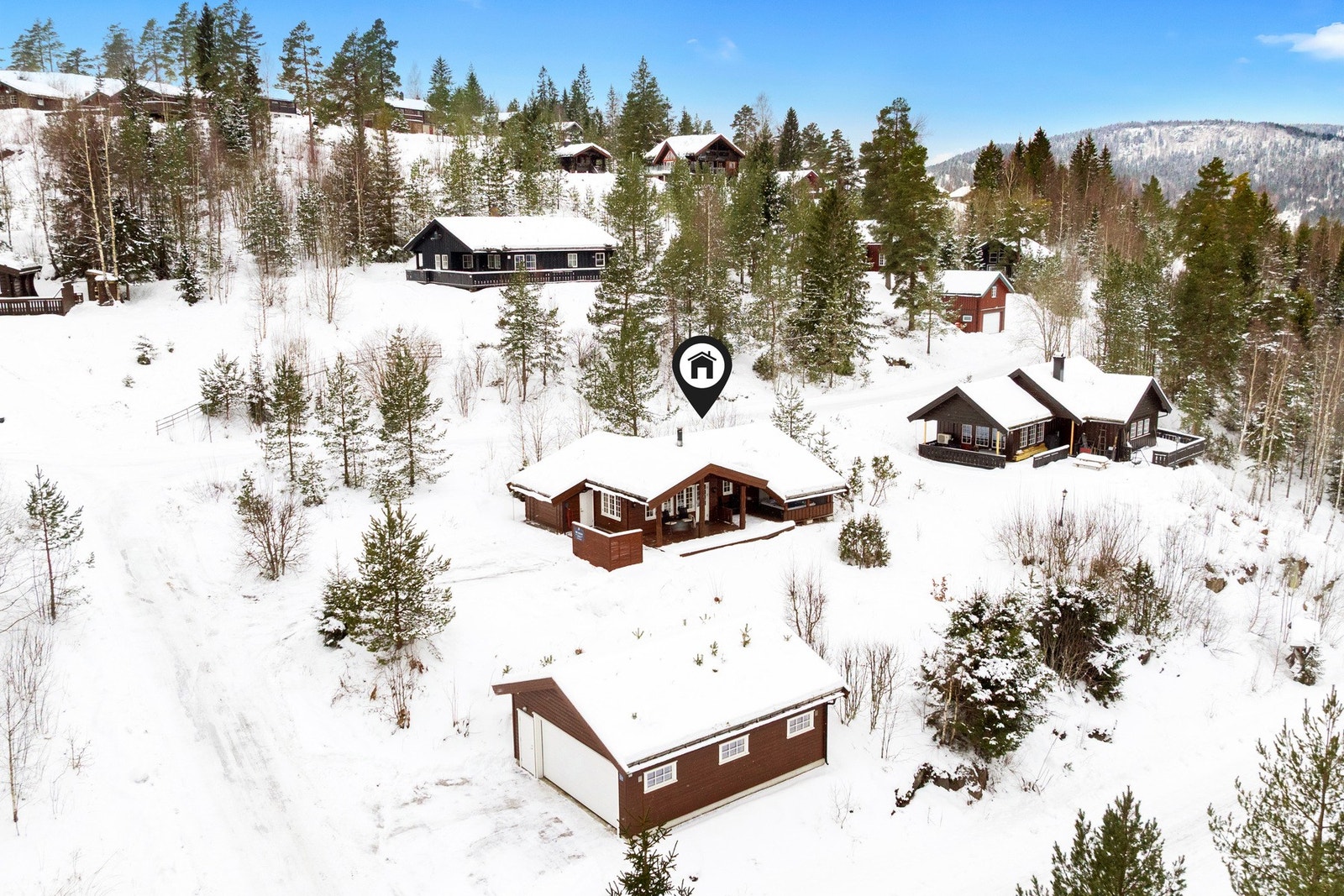 Hytta ligger i et veletablert hytteområde i Svarstad. Dobbelgarasjen ble satt opp i 2013. Galleribilde