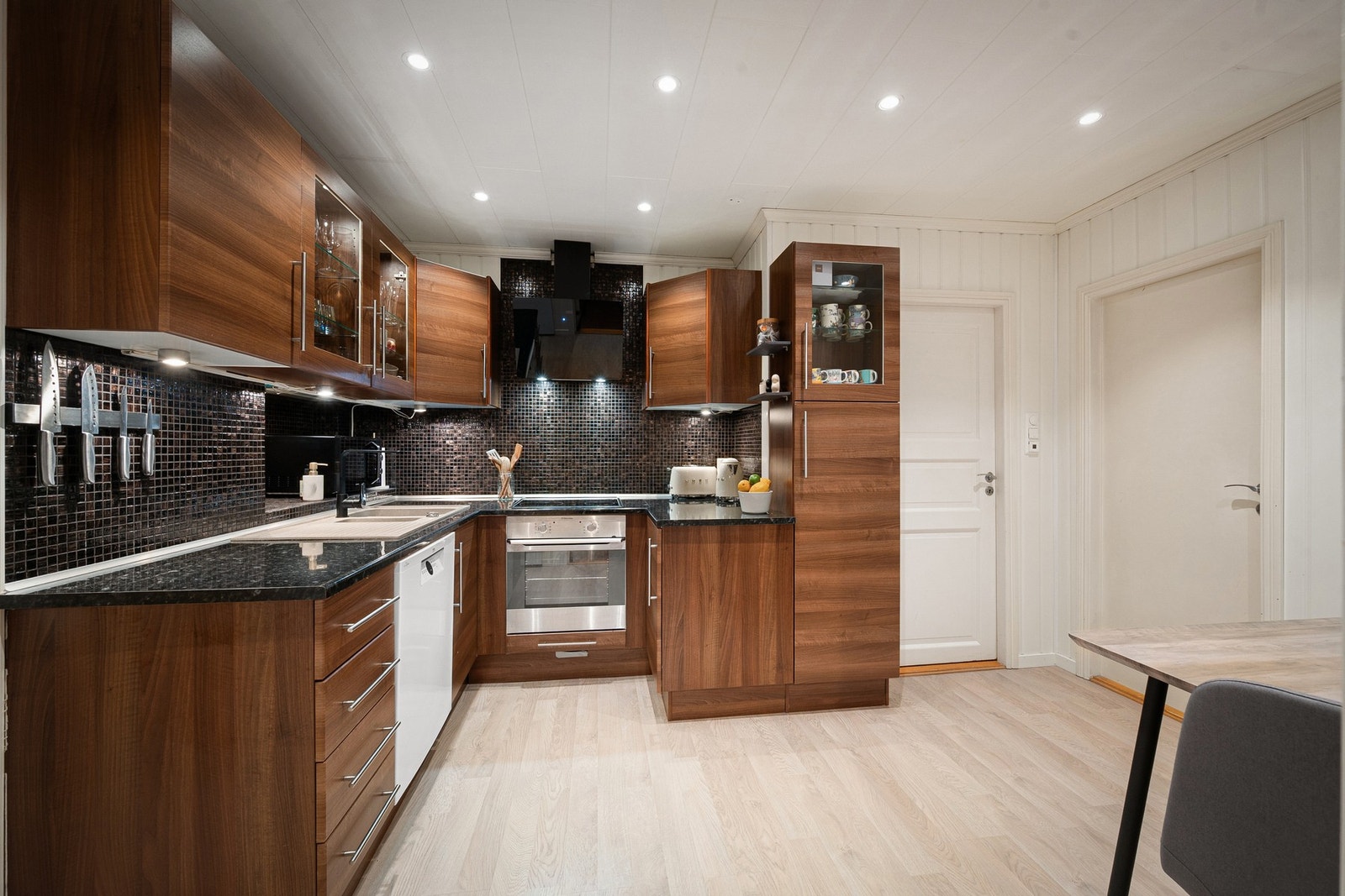 Flott innredning med mørke, glatte fronter og god belysning med downlights i tak og under benkeskap Galleribilde