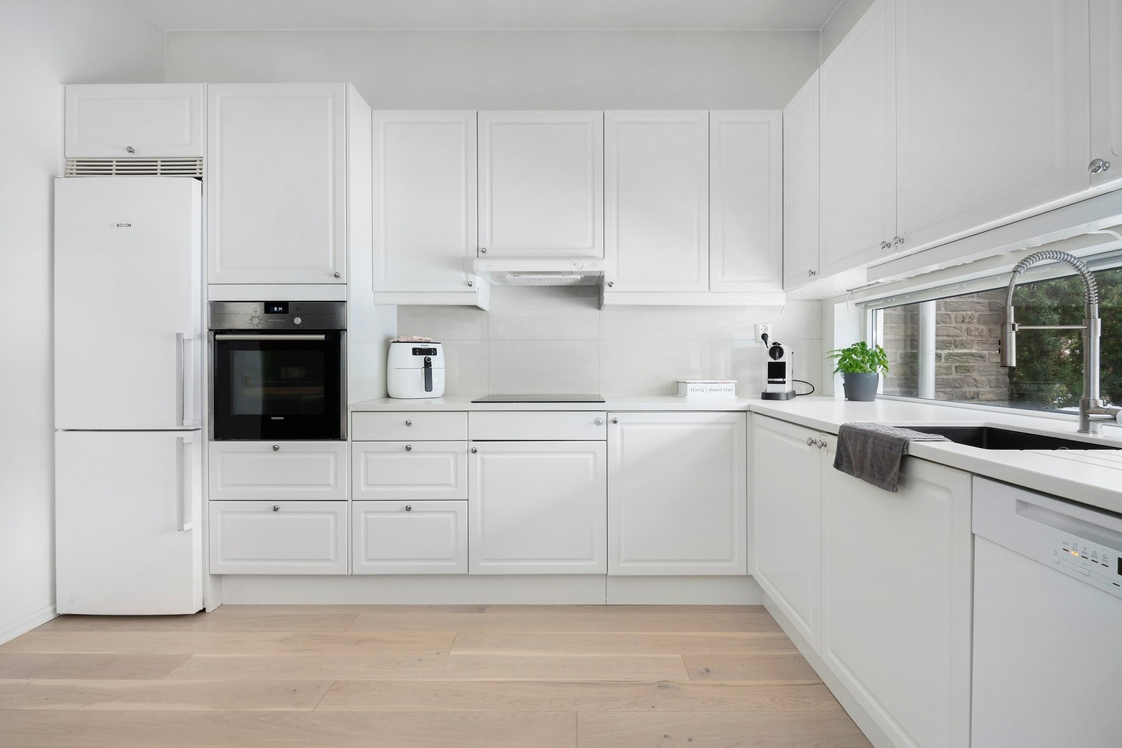 Kjøkkeninnredning med profilerte fronter og benkeplate av stein Galleribilde