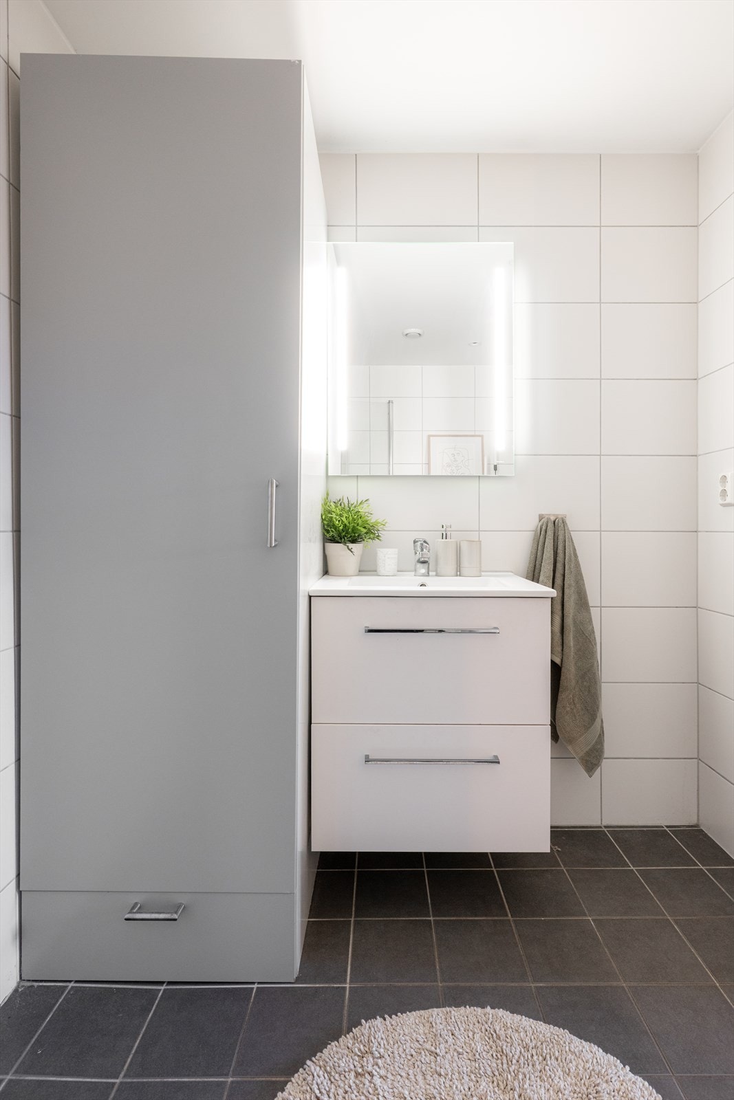 Innfelte spotter i himlingen sørger for behagelig belysning. Godt med skapplass - baderomsmøbler med hvite, slette fronter, speil og dusjnisje med glassdører. Galleribilde