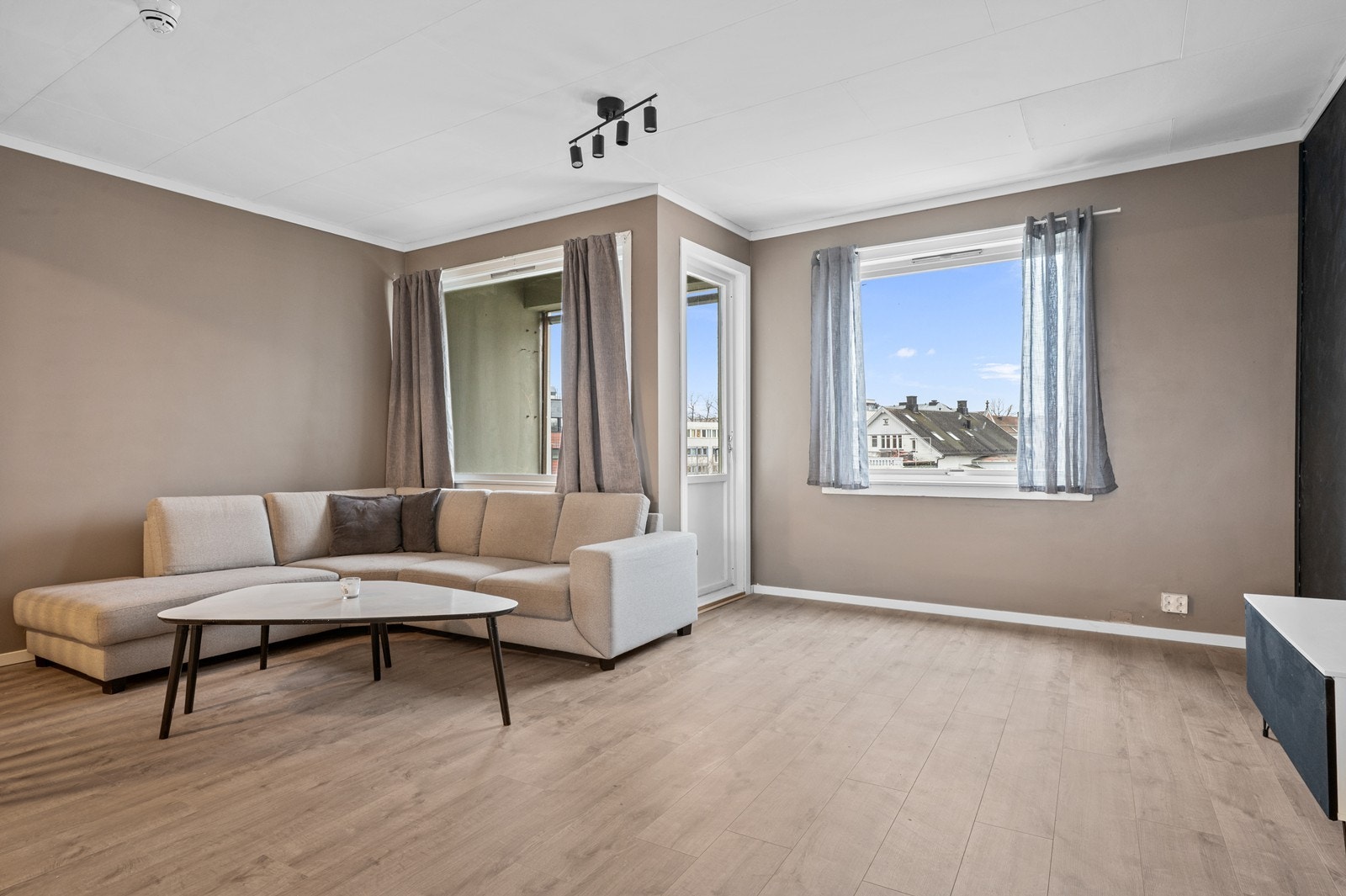 Stuen har store vindusflater som gir rikelig med naturlig lys. Stue uten styling. Galleribilde