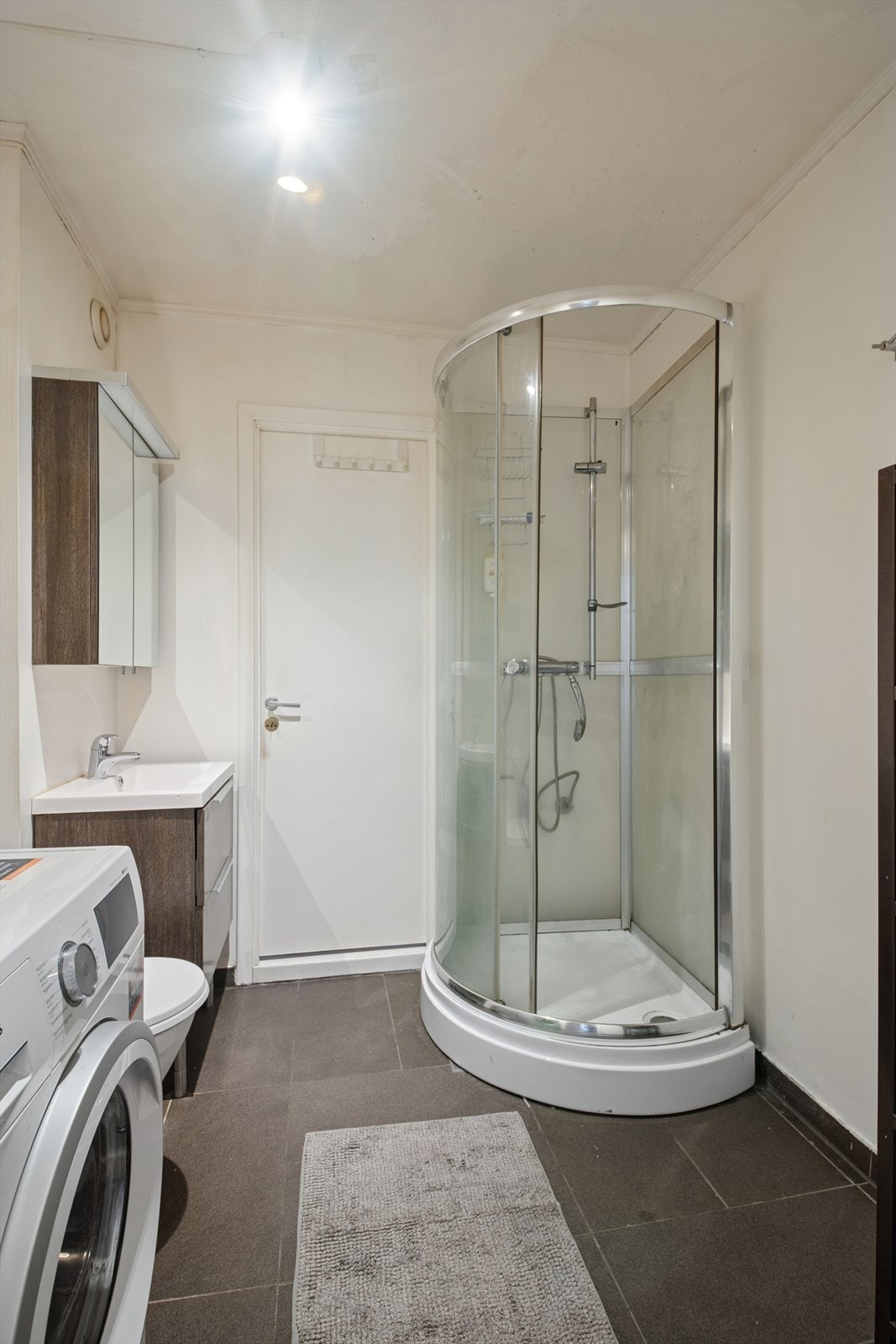 Baderommet er utstyrt med servant, dusjkabinett og opplegg til vaskemaskin. Galleribilde