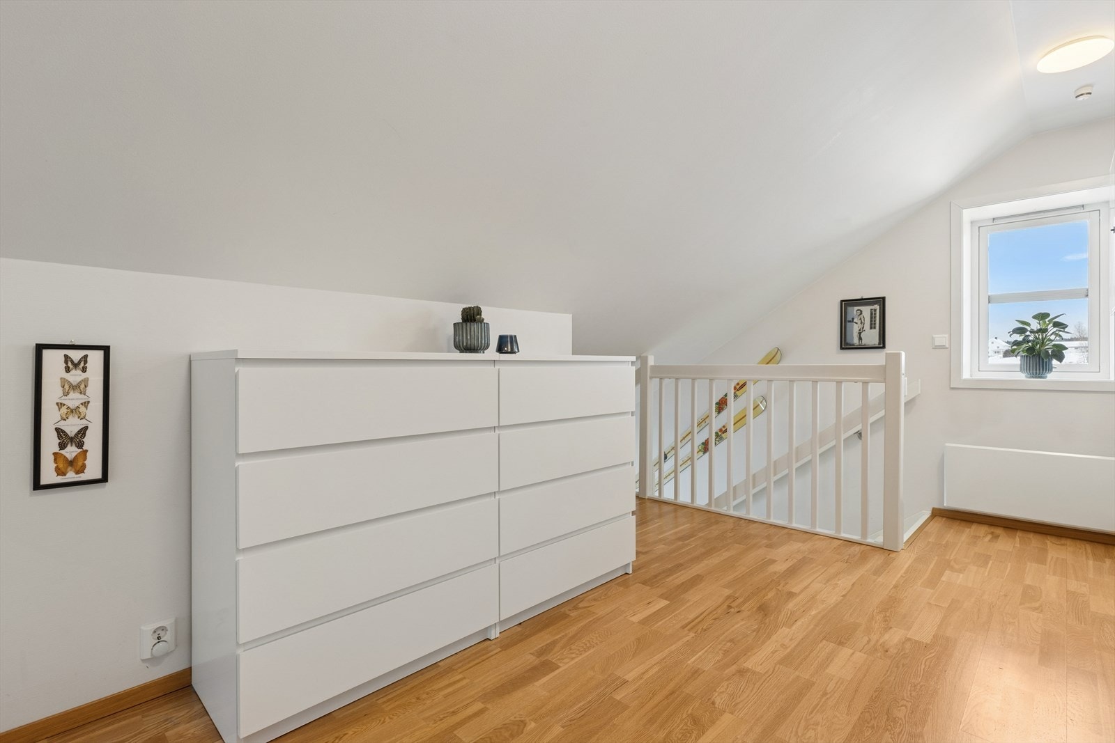 Lys loftsgang som ønsker deg velkommen inn i den åpne og luftige leiligheten. Galleribilde