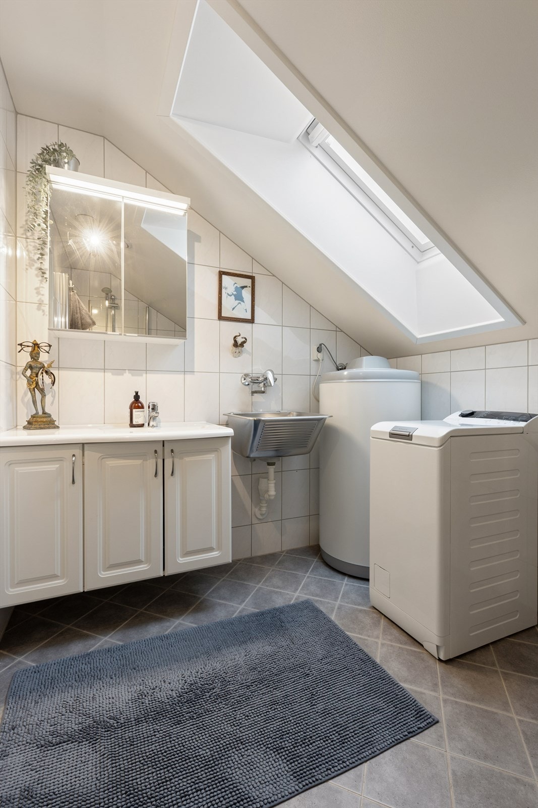 Flislagt bad med varme i gulvet og naturlig dagslys fra takvindu. Galleribilde