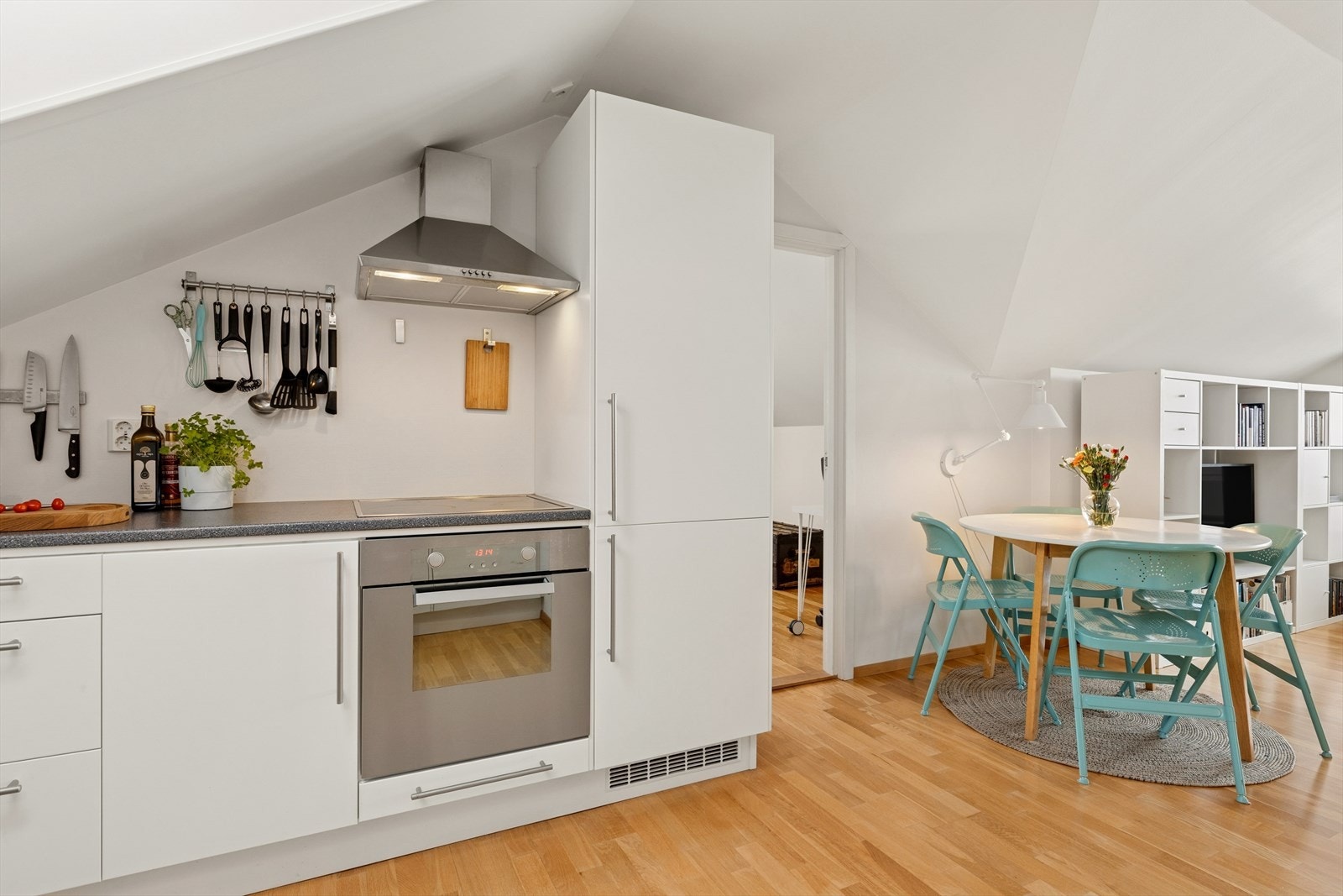 Lyst og moderne kjøkken med glatte fronter og integrerte hvitevarer. Galleribilde