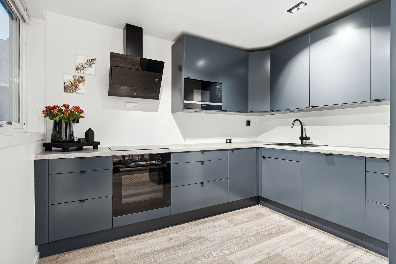 Kjøkkenet er innredet med slette fronter, normalt utbygget med benkeplass og overskap Galleribilde