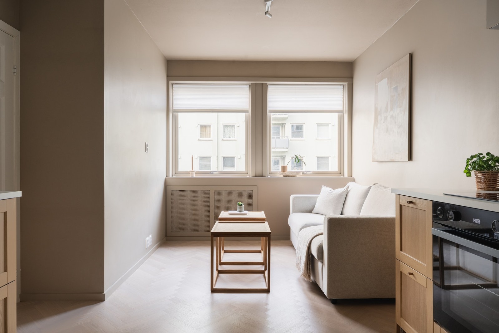 Åpen løsning mellom stue og kjøkken på 12,5 kvm med 1-stavs fiskebensparkett på gulv. Galleribilde