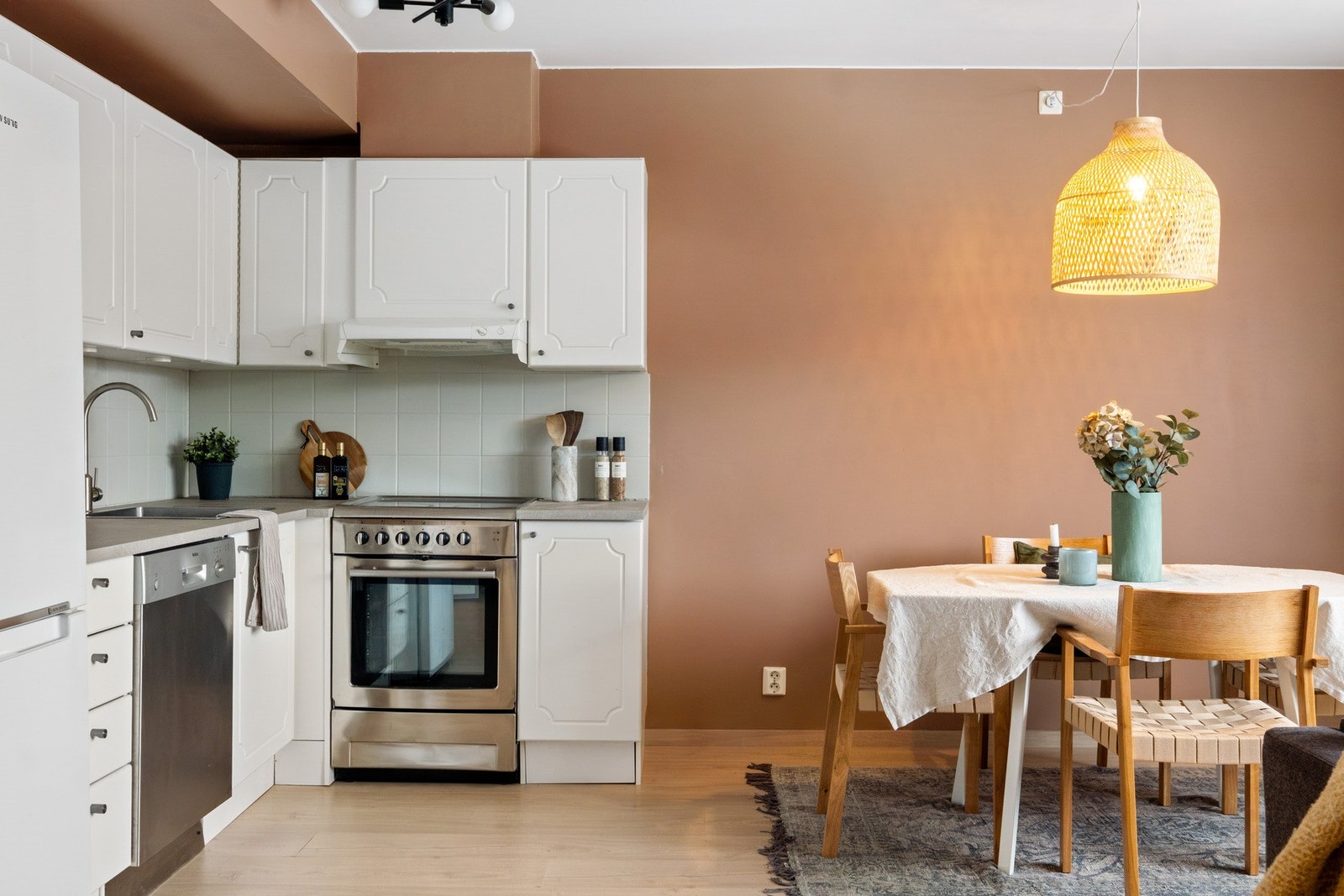 Åpen kjøkkenløsning med profilerte fronter og benkeplate av laminat. Benkeplaten er ny fra 2026. Flisene ble også malt i 2026. Galleribilde