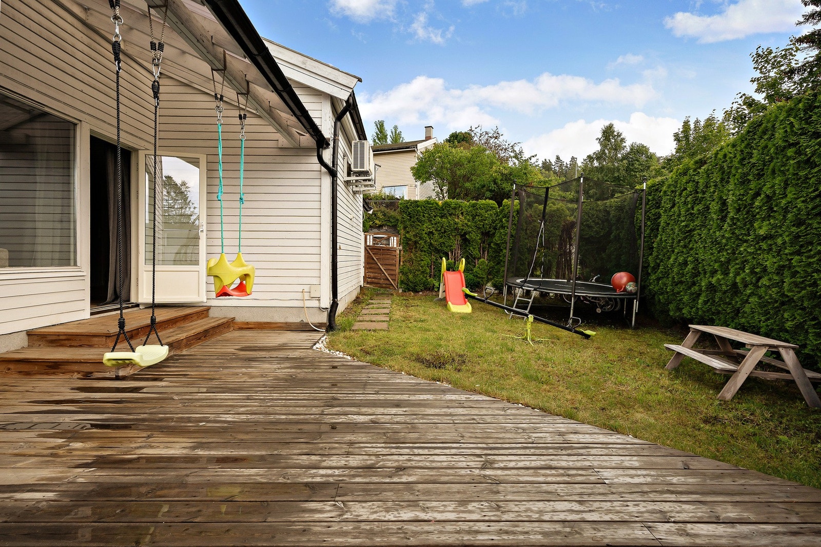 Det er dør inn til en bod med plass til hageredskaper, verktøy og annen lagring. Galleribilde