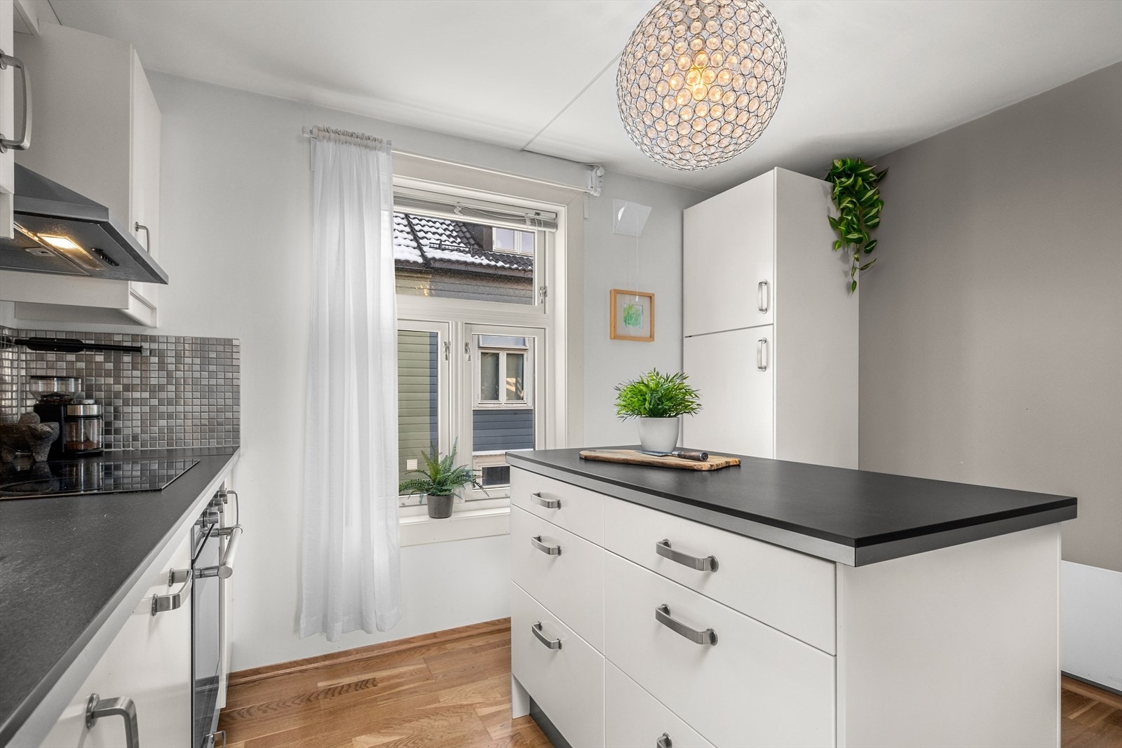 Kjøkkenøya gir en naturlig avgrensning mellom kjøkkenet og spisebordsone, som bidrar til en romligere atmosfære Galleribilde