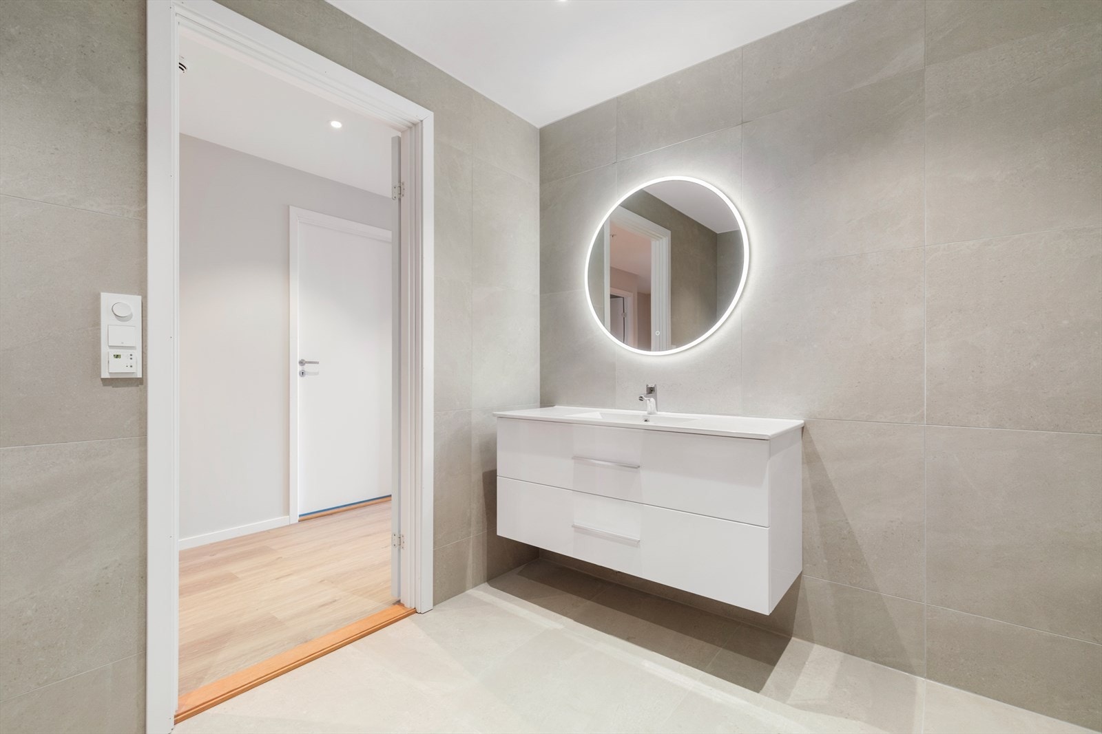 Helfliset bad med 60*60 flis, vegghengt toalett, stor dusjnisje og praktisk baderomsinnredning. Galleribilde