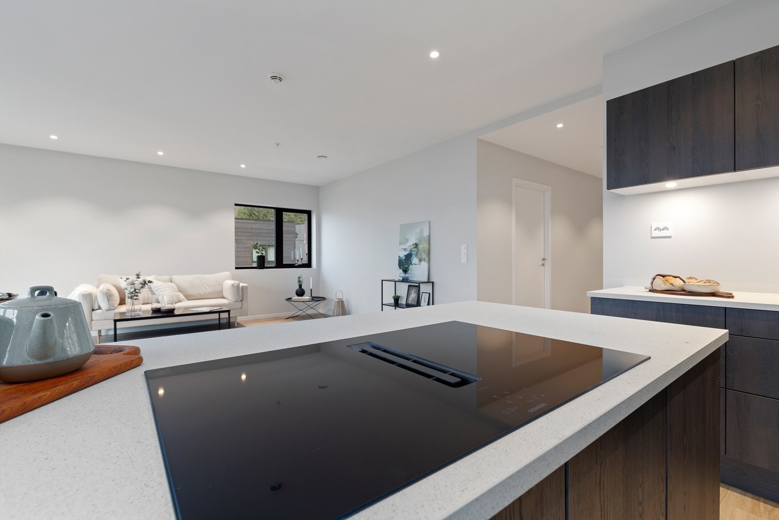 Leiligheten har en lys og åpen stue med ekstra takhøyde og slette flater Galleribilde