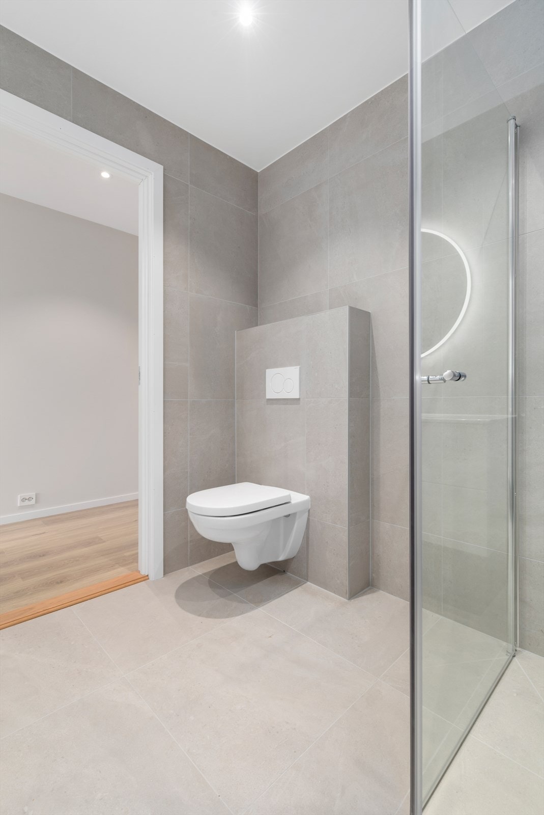 Helfliset bad med 60*60 flis, vegghengt toalett, stor dusjnisje og praktisk baderomsinnredning. Galleribilde