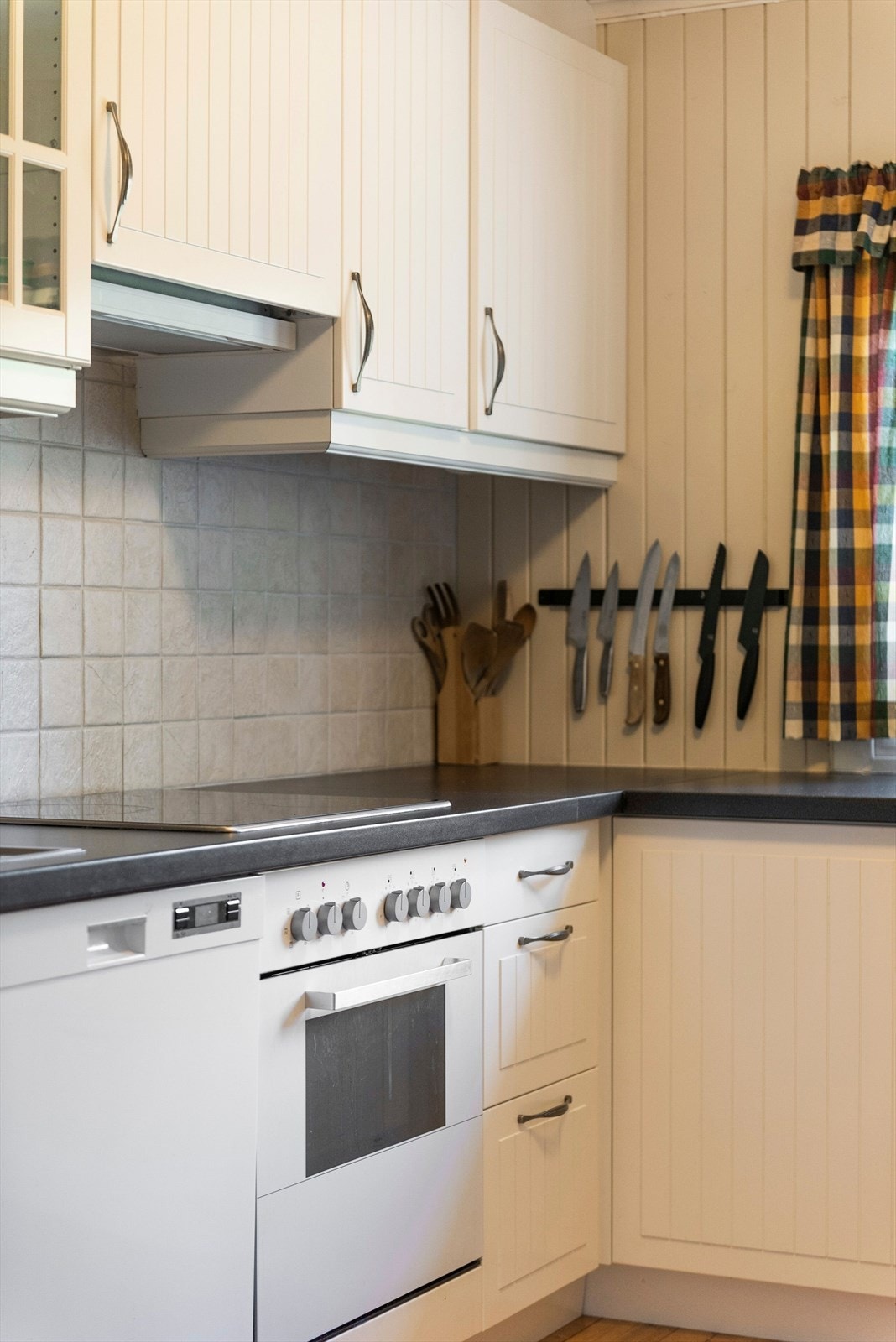 Fullstandard kjøkken med integrert koketopp, komfyr, oppvaskmaskin og frittstående kjøleskap. Galleribilde