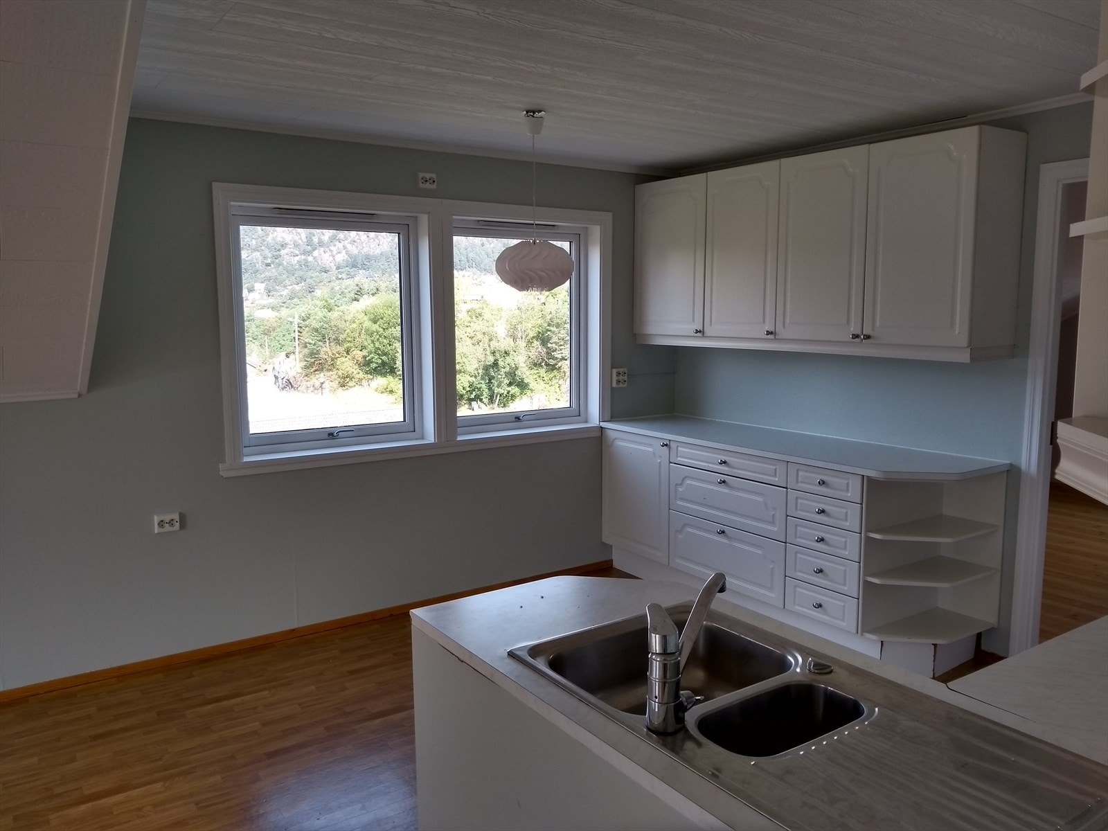 Kjøkken i loftsetasjen med profilerte fronter og benkeplate av laminat. Galleribilde