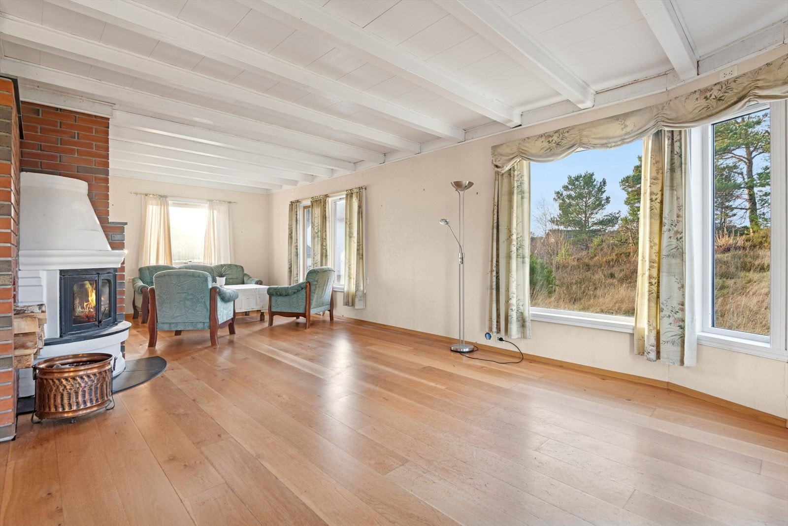 Vedovn i stuen bidrar med jevn varme. Rommet har god plass til møblering i ulike soner. Galleribilde