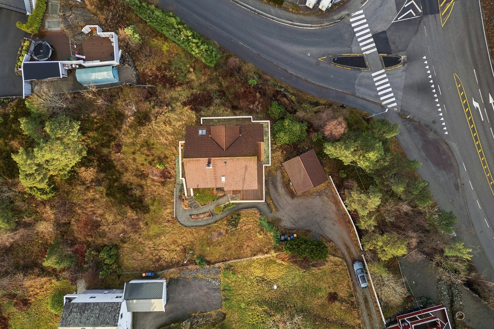 Eiendommen er på 2 173 kvm opparbeidet med gruset innkjørsel, naturtomt, bed og noe beplantning. Galleribilde