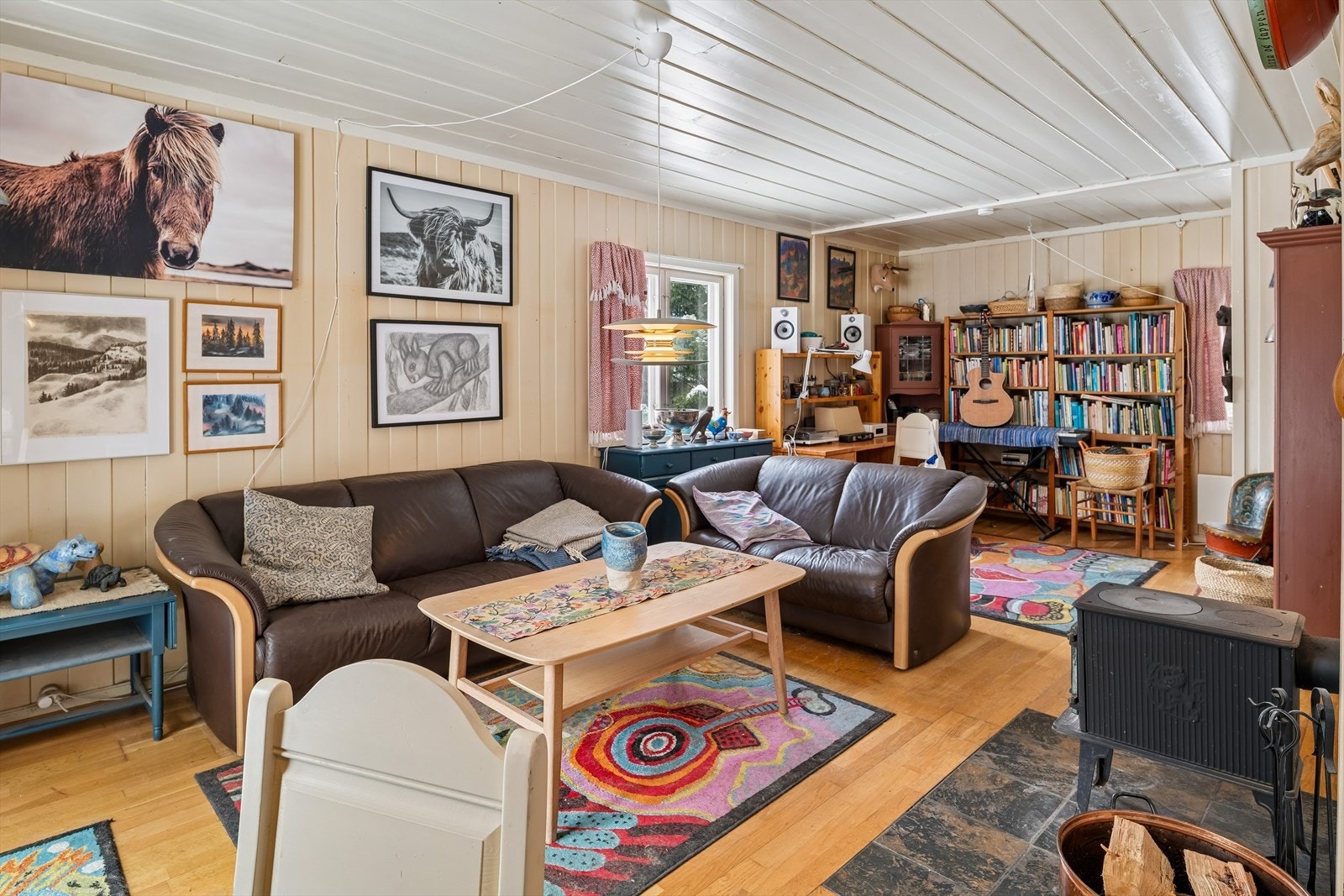 Stuen har parkett på gulv og vegger med malt panel. Galleribilde