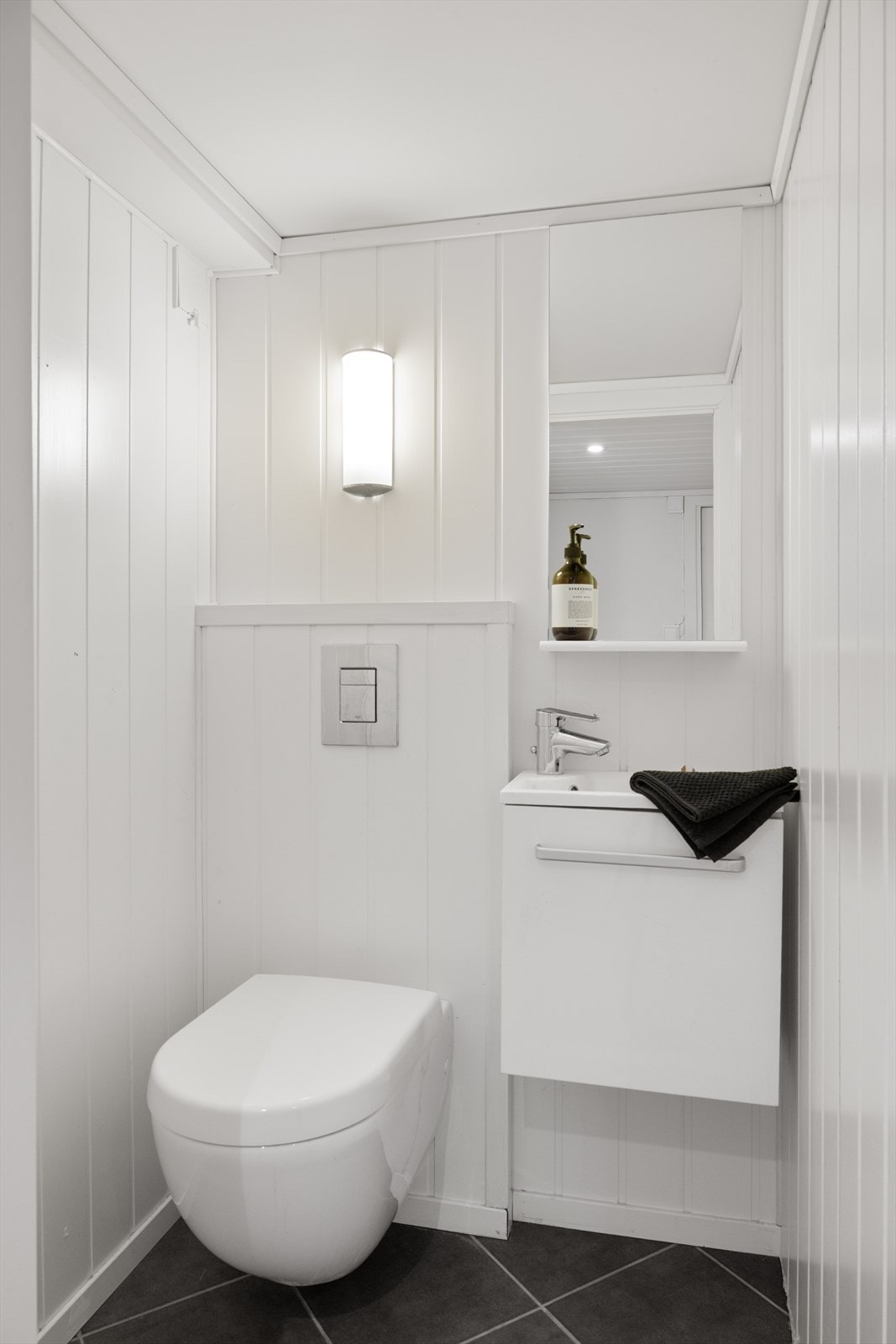 Praktisk gjestetoalett med vegghengt toalett og servant med underskap. Galleribilde