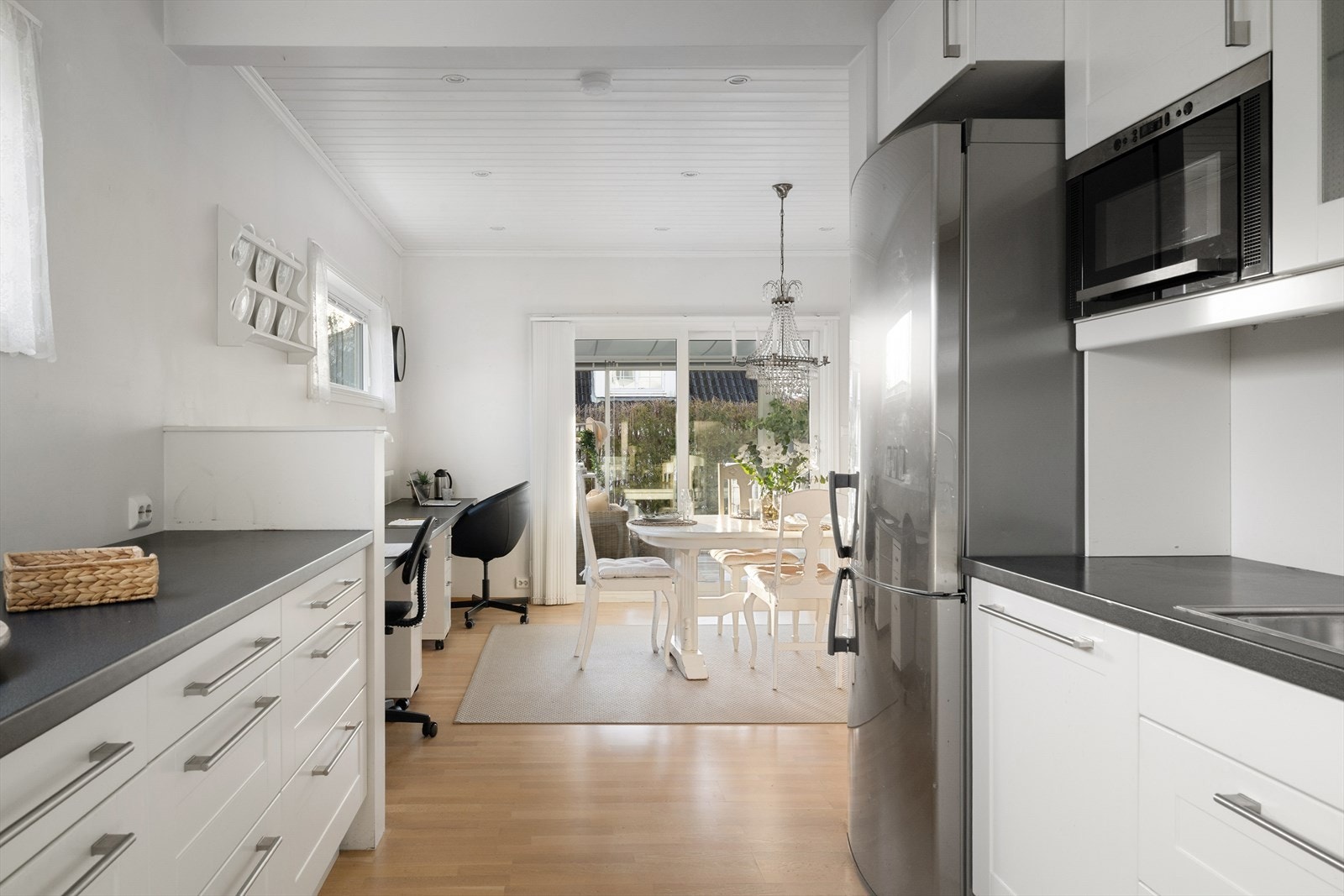 Kjøkkenet har en naturlig overgang mot spiseplass og uteområde, noe som gir en luftig og sosial romfølelse. Galleribilde