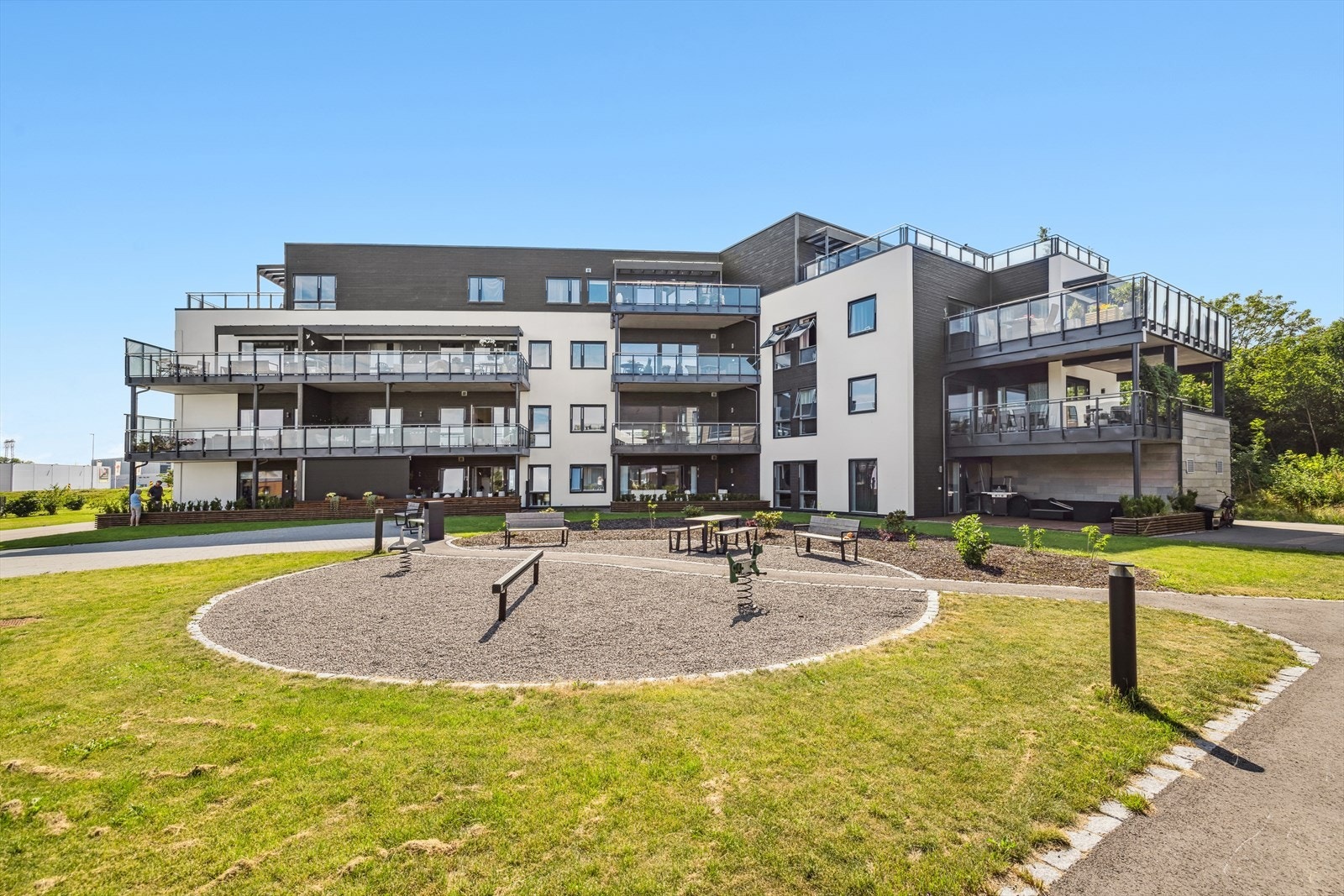 Felles tomt for borettslaget som er pent opparbeidet med gressplen, gangveier og bebyggelse. Galleribilde