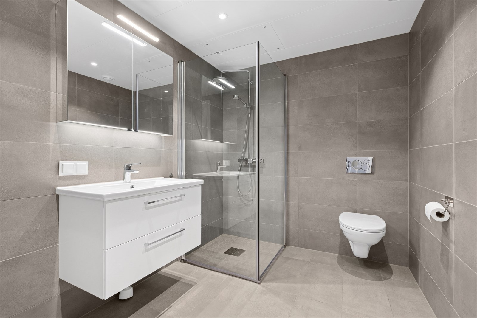 Det andre badet er gjennomført med flotte fliser i moderne fargetoner på vegger og gulv. Det er i tillegg behagelige varmekabler i gulvet. Galleribilde