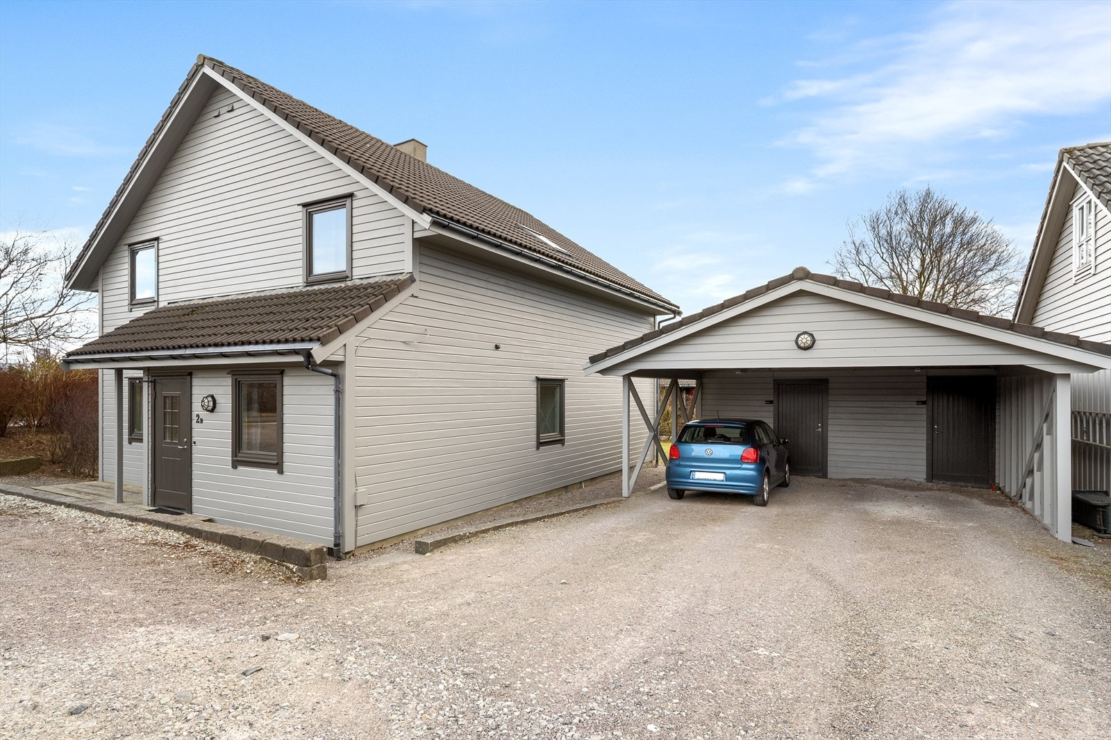 Carport med en biloppstillingsplass. Innenfor carport er det en praktisk bod. Galleribilde