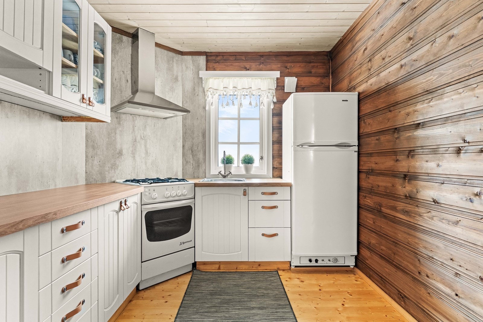 Lyst og pent kjøkken med godt med skap- og benkeplass. Laminerte fronter og skrog. Galleribilde