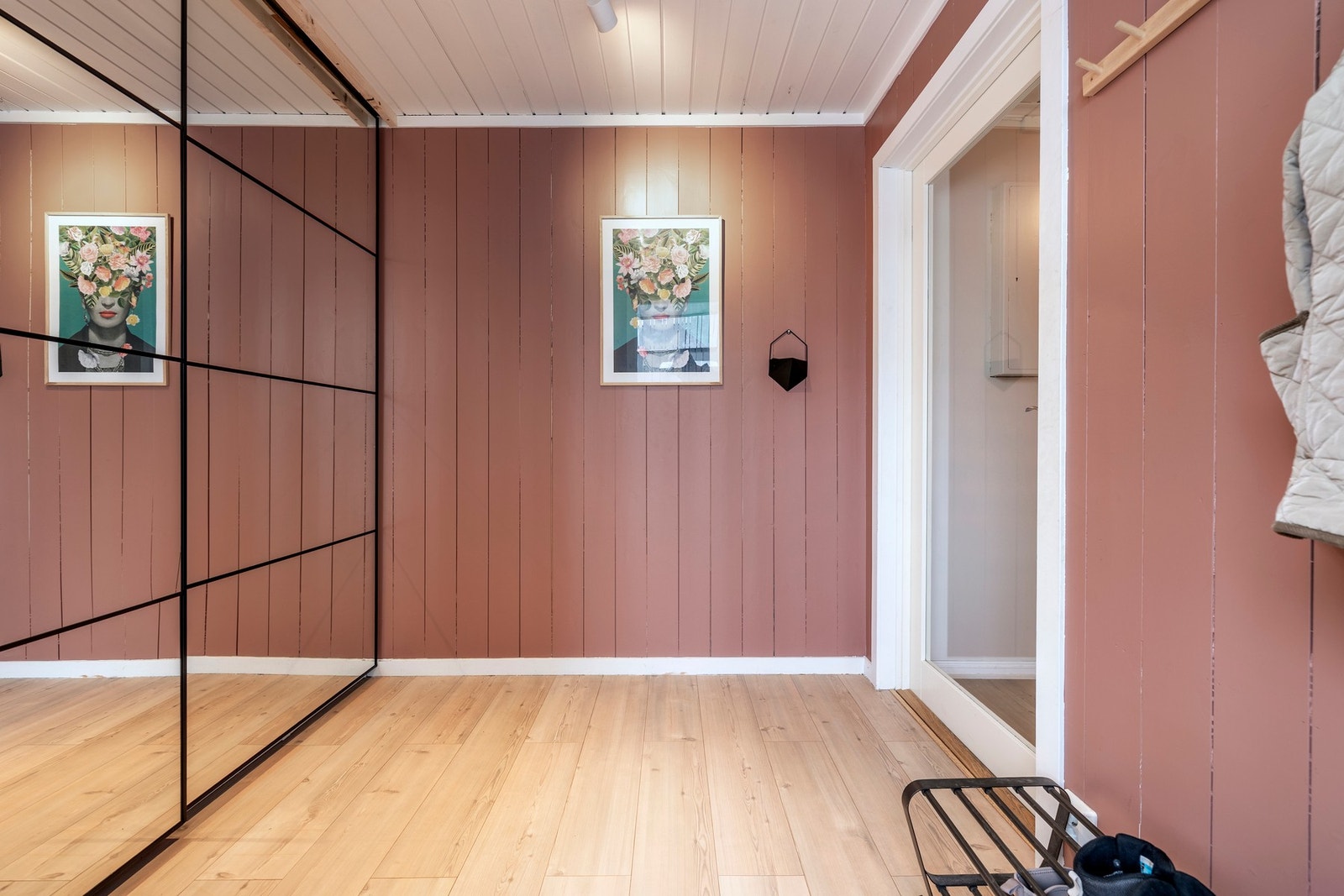 Entréen er romslig, malt i spreke fargetoner kombinert med laminatgulv. Rommet er innredet med knaggoppheng og en skyvedørsgarderobe med speilfronter som gir rikelig med plass til yttertøy, sko og annet utstyr. Galleribilde