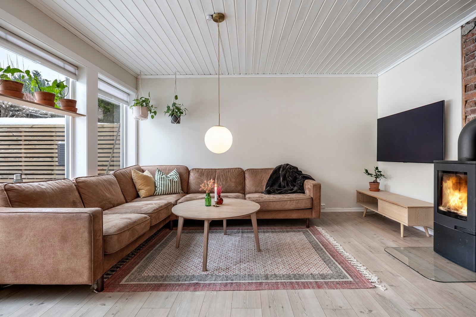 Stuen oppleves som luftig og romslig med god plass til sofagruppe og TV-anlegg. Rommet er malt i moderne fargetoner, gulvet er belagt med laminat og store vindusflater slipper inn rikelig med naturlig lys. En nyere peisovn med flammeinnsyn bidrar med ekst Galleribilde