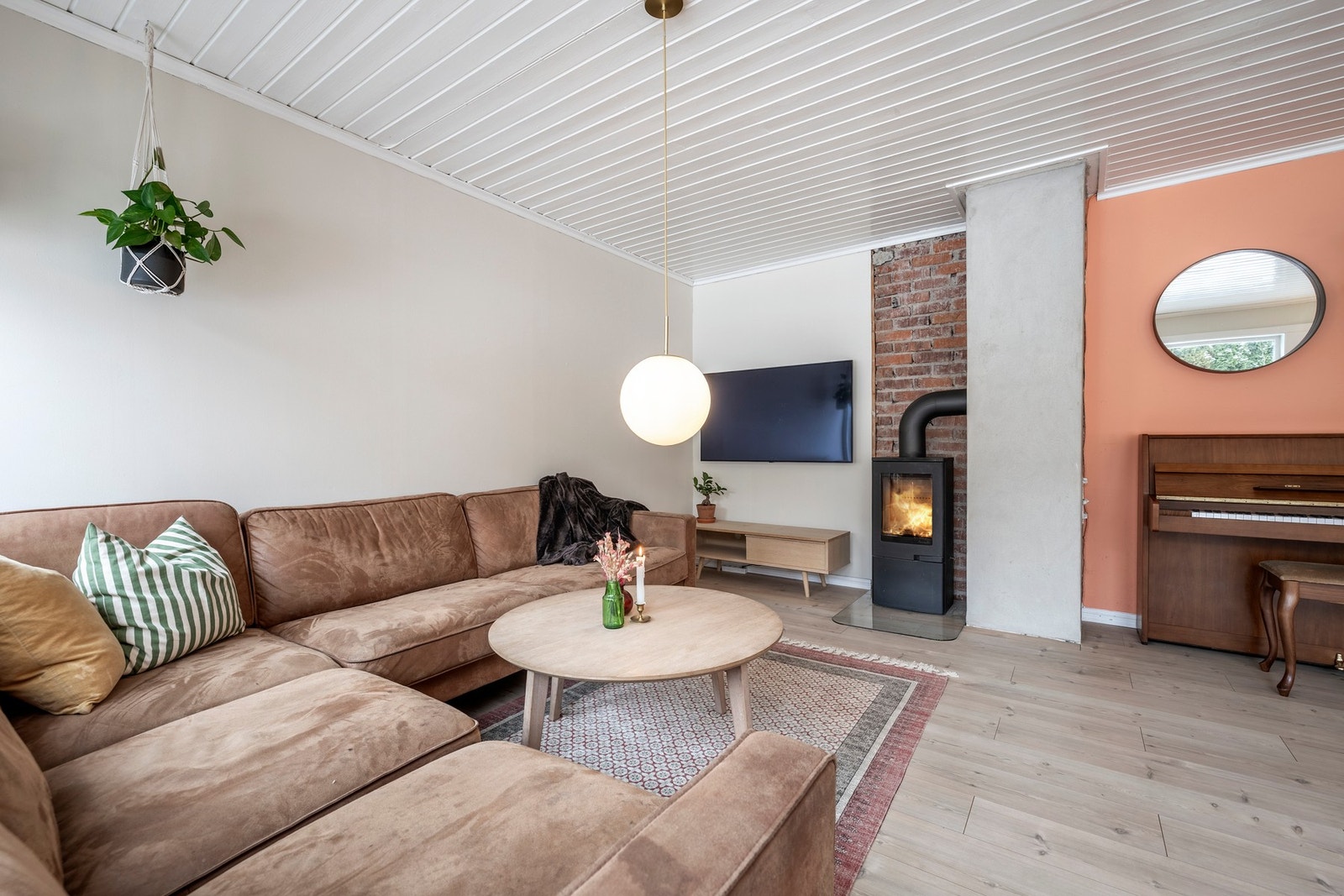 Stuen oppleves som luftig og romslig med god plass til sofagruppe og TV-anlegg. Rommet er malt i moderne fargetoner, gulvet er belagt med laminat og store vindusflater slipper inn rikelig med naturlig lys. En nyere peisovn med flammeinnsyn bidrar med ekst Galleribilde