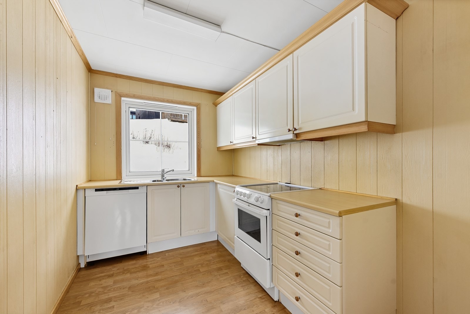 Kjøkkenet har en funksjonell innredning med profilerte fronter og laminat benkeplate. Galleribilde