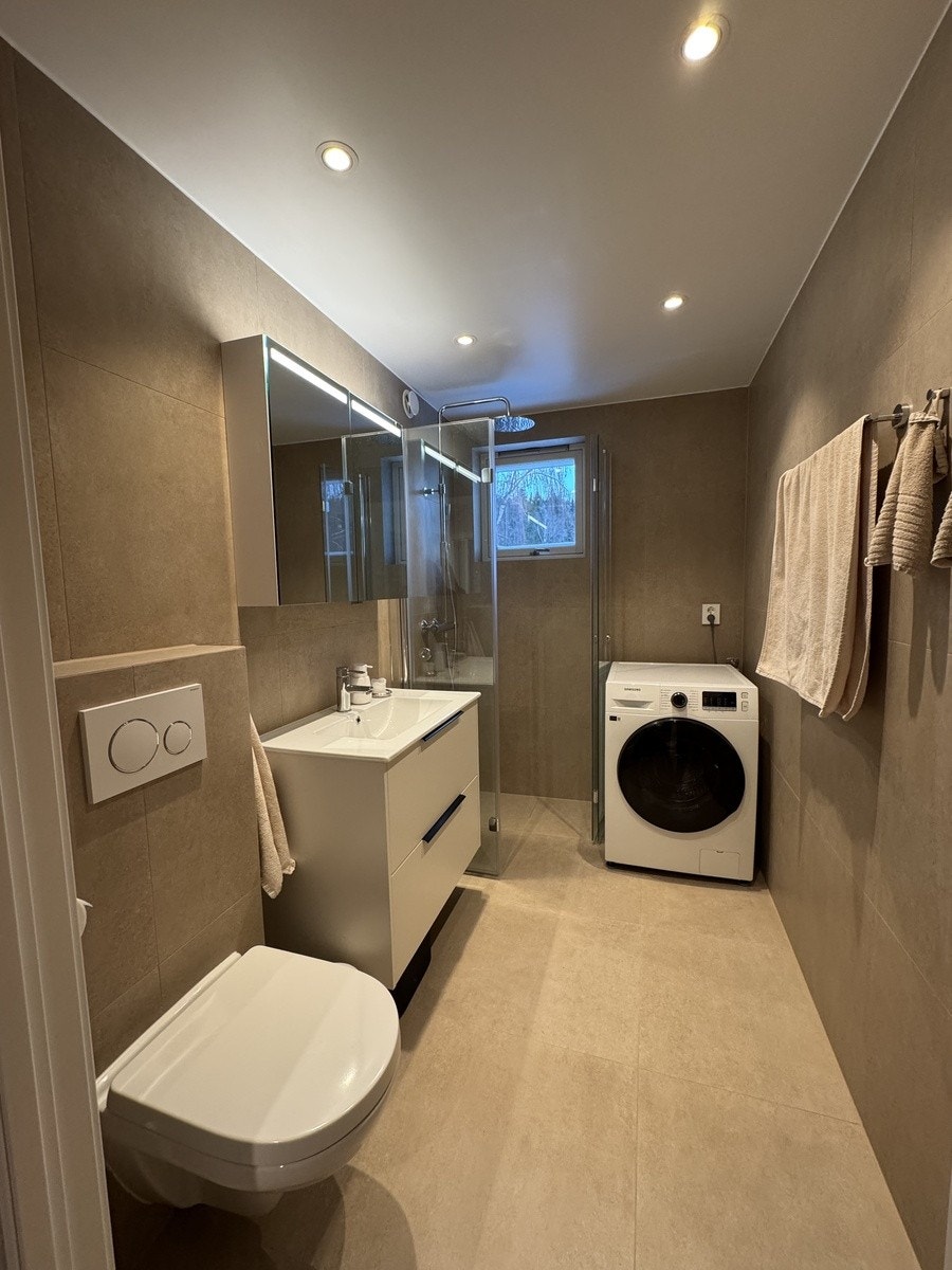 Bad med god oppbevaringsplass og kombinert vaskemaskin med tørketrommel Galleribilde