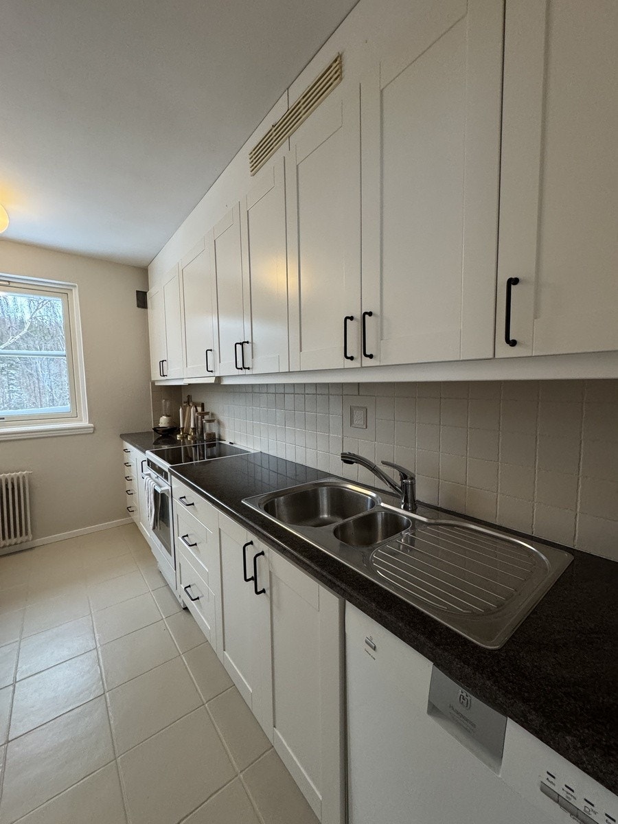 Kjøkken med god oppbevaringsplass, oppvaskmaskin, komfyr og kjøleskap Galleribilde