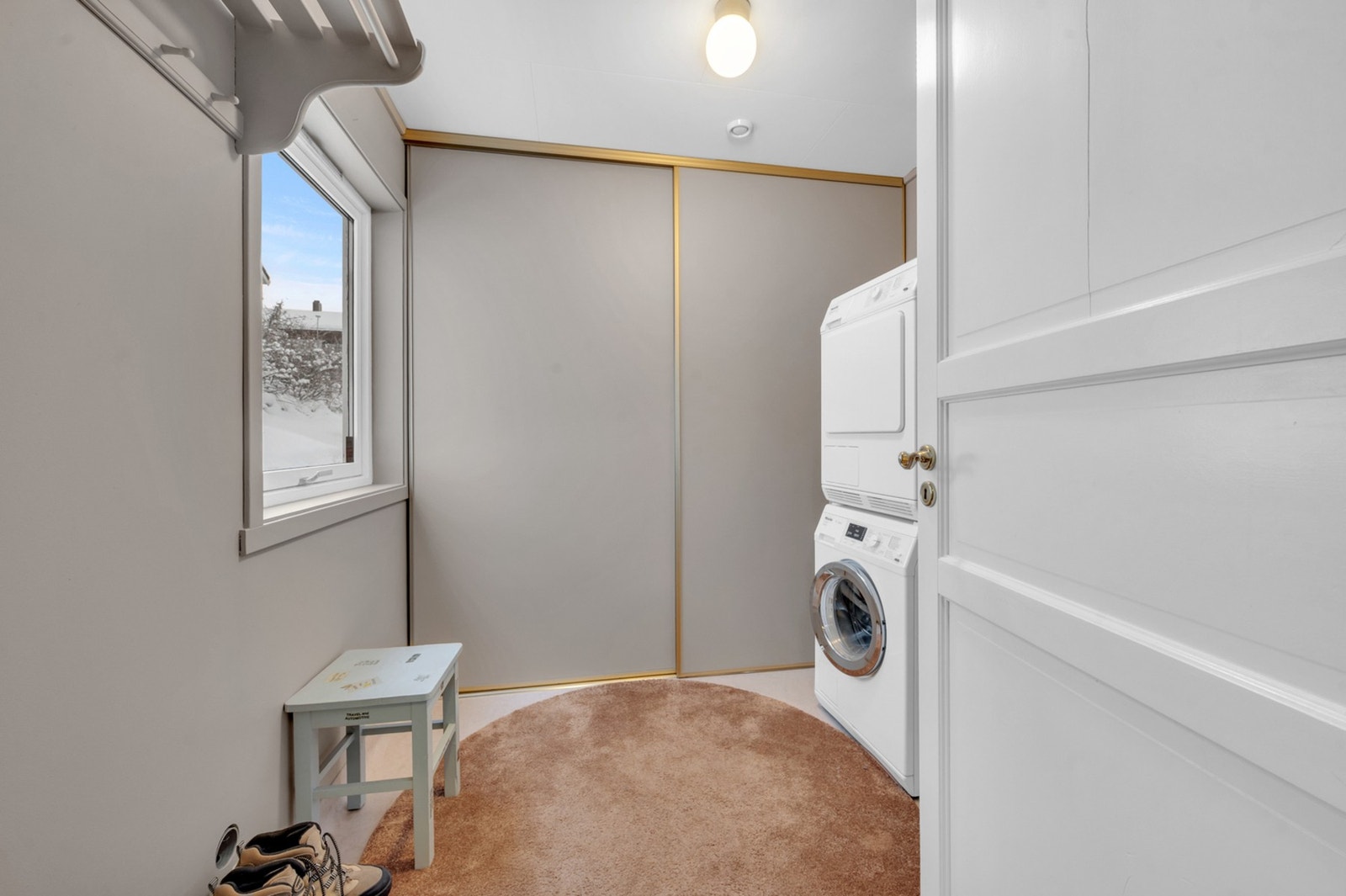 Ryddig og praktisk vaskerom med skyvedører. Galleribilde