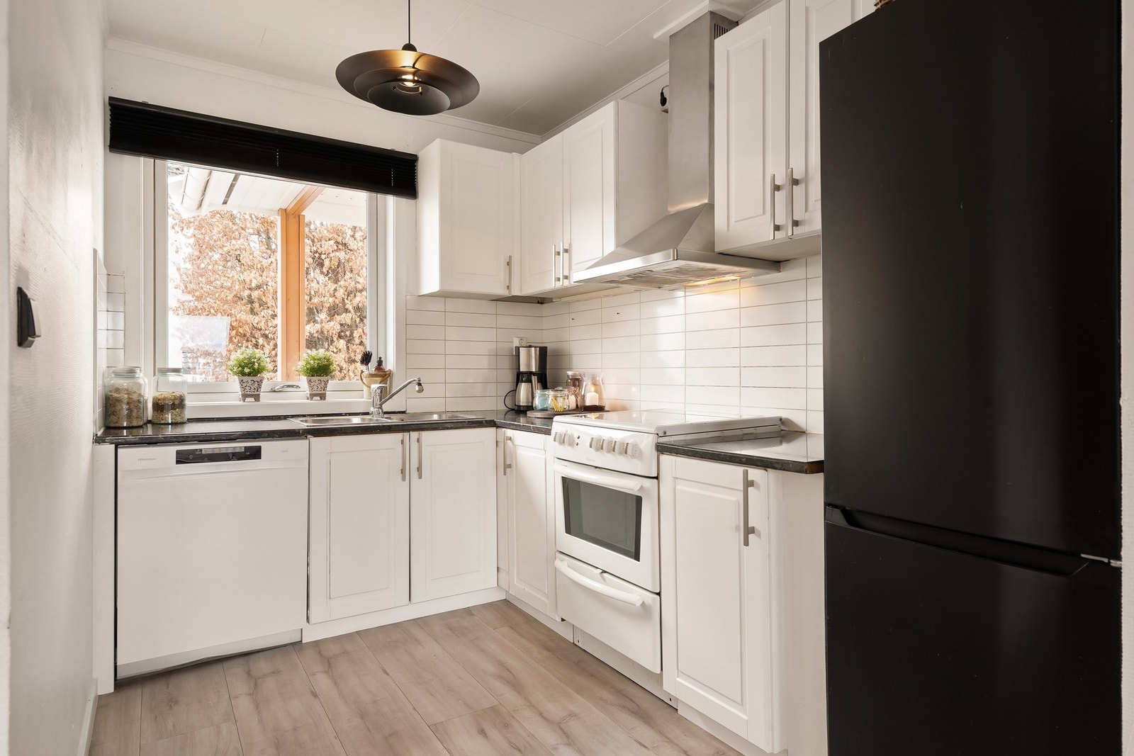 Lyst og funksjonelt kjøkken. Innredningen har malte skapfronter i profilert utførelse, og laminert benkeplate. Galleribilde