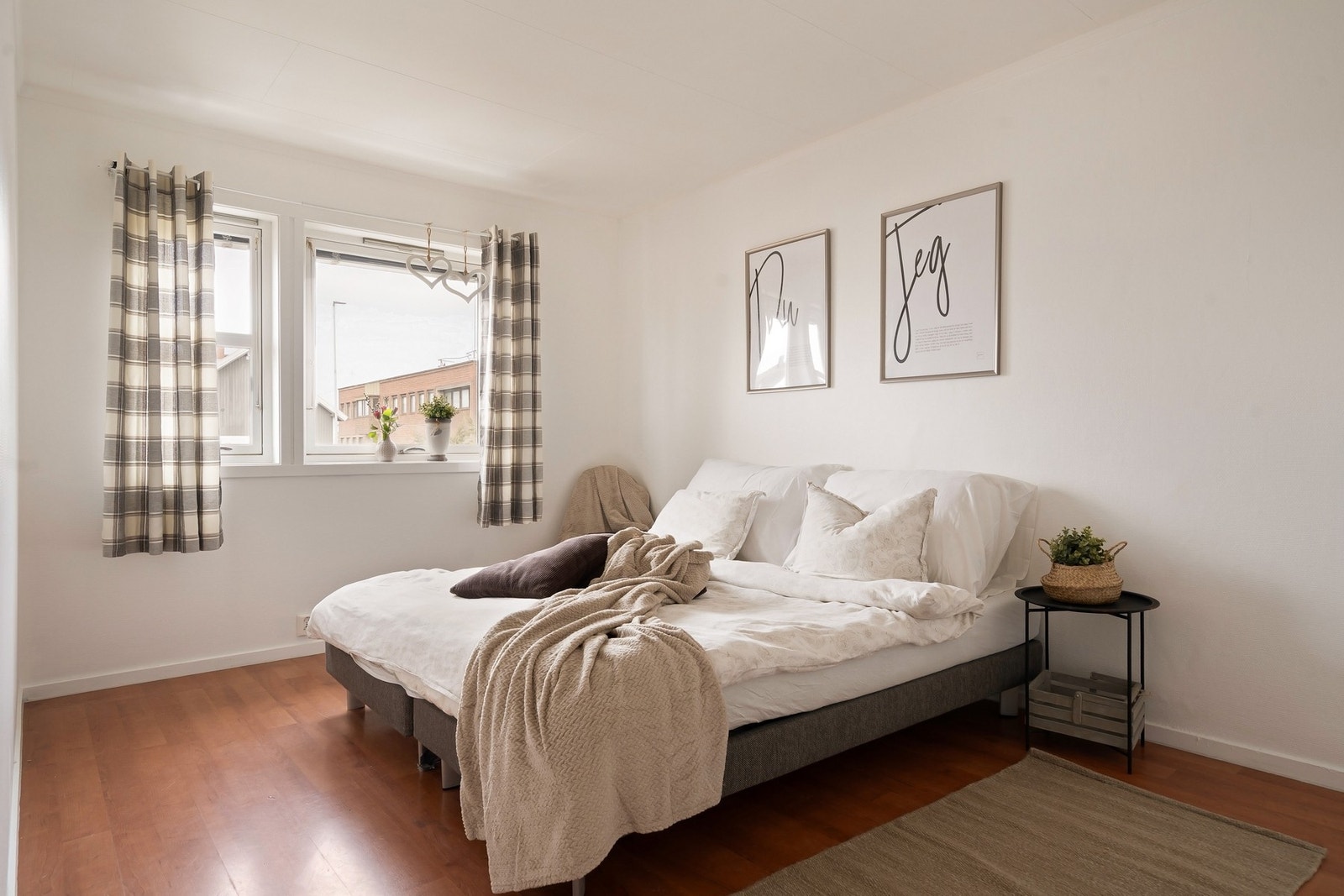 Romslig soverom med plass til en stor seng og nattbord. Galleribilde