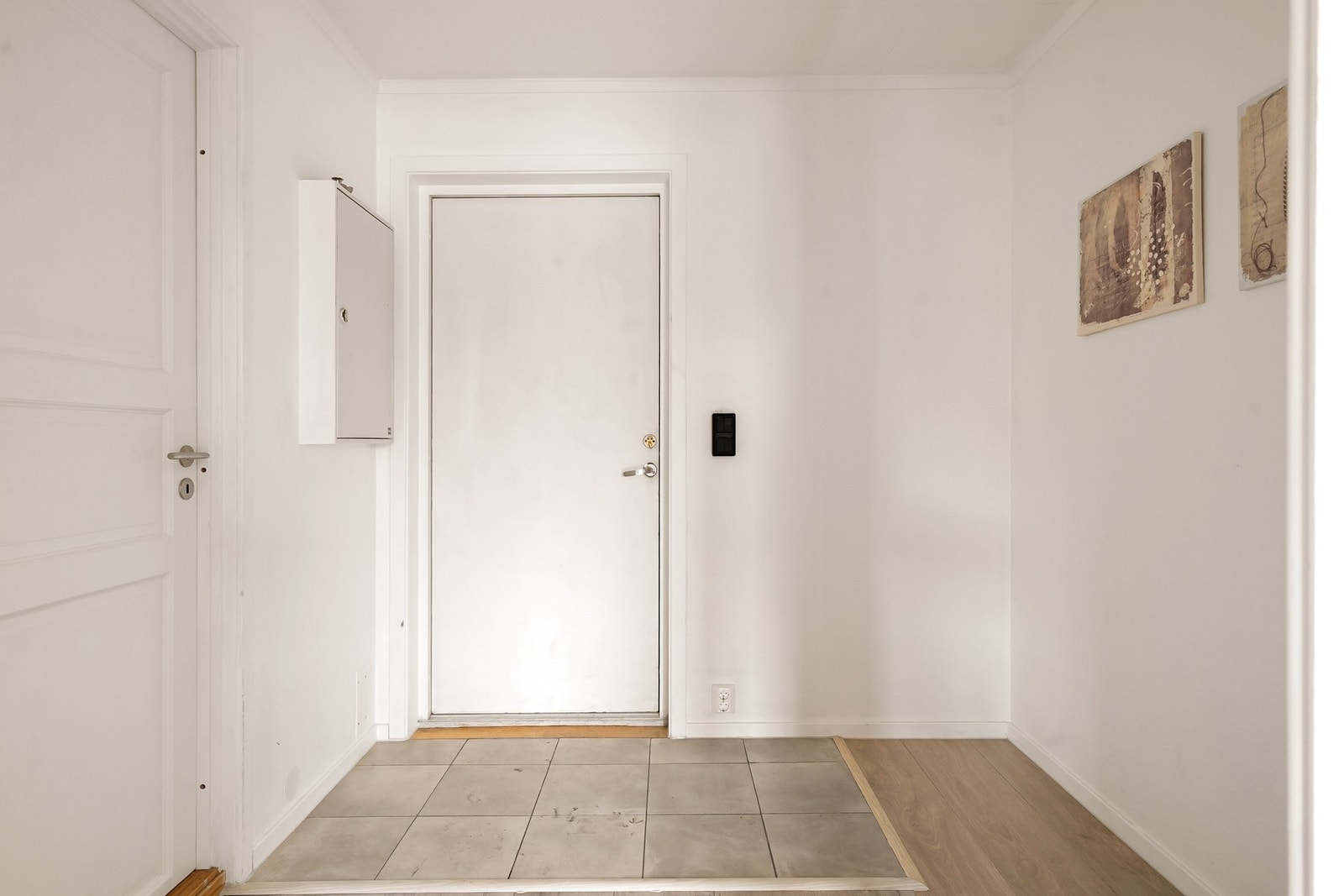 Romslig entré med praktiske fliser på gulvet. Galleribilde