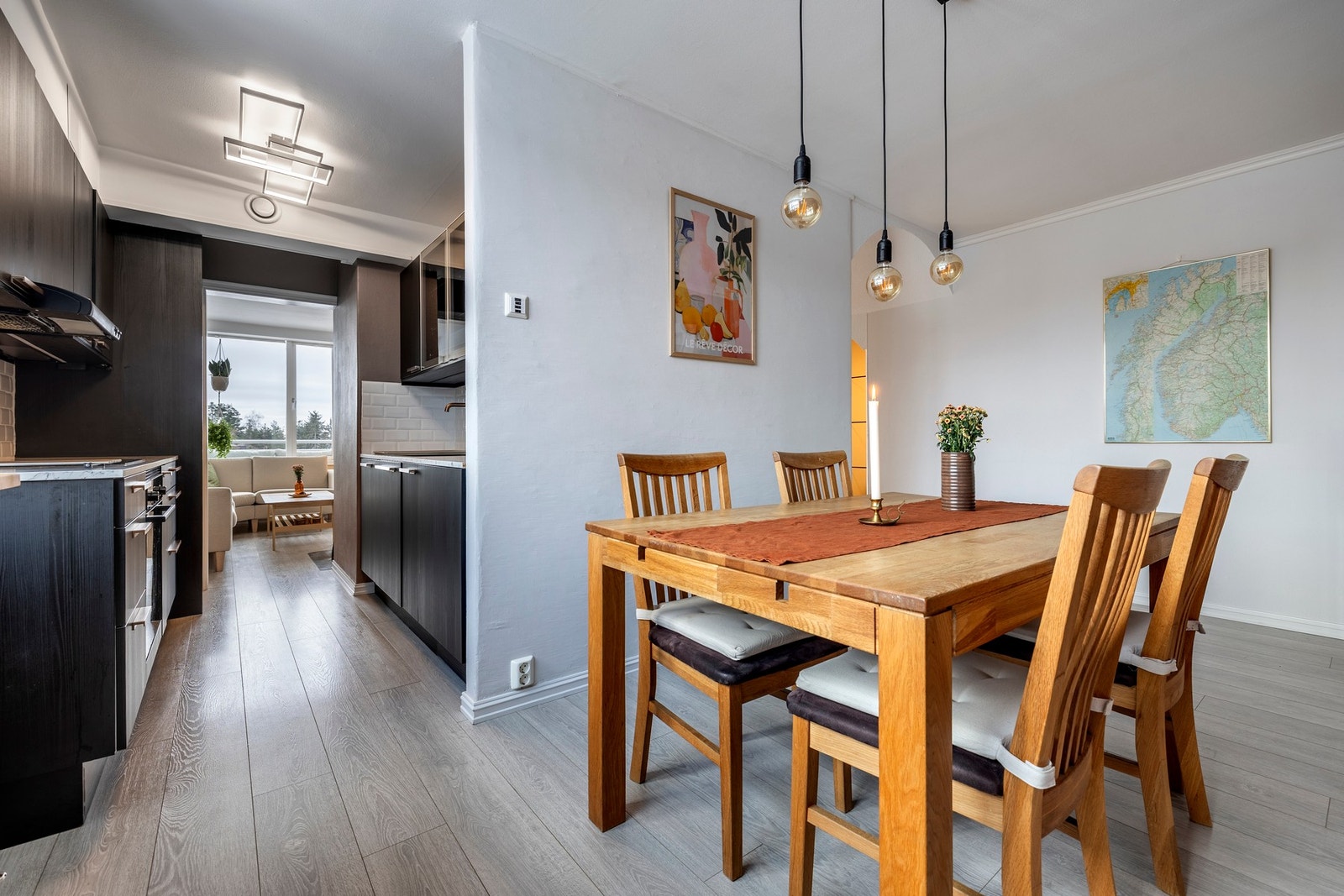 Stuen og spisestuen er praktisk plassert på hver sin side av kjøkkenet, noe som gir to separate soner. Begge rommene har store vindusflater som slipper inn rikelig med naturlig dagslys, moderne fargetoner og laminatgulv. Galleribilde