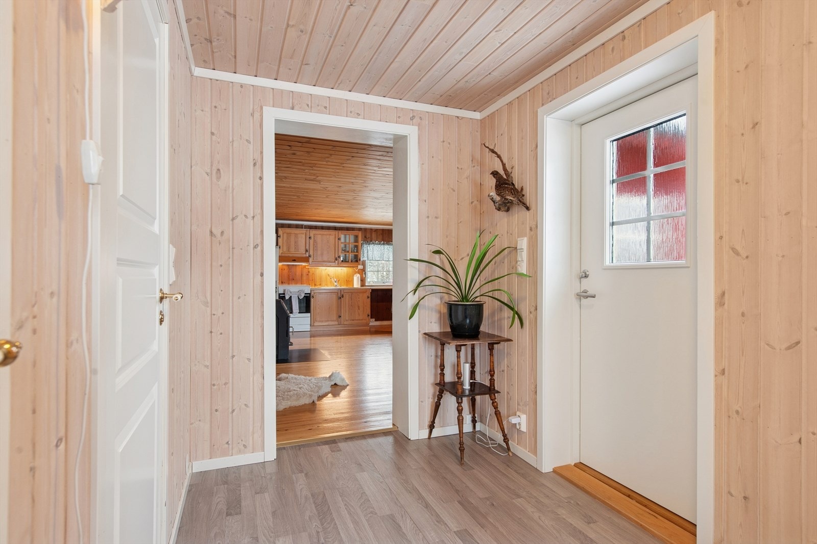 Inngangspartiet er lyst og innbydende med hvitlakkert ytterdør med glass. Galleribilde