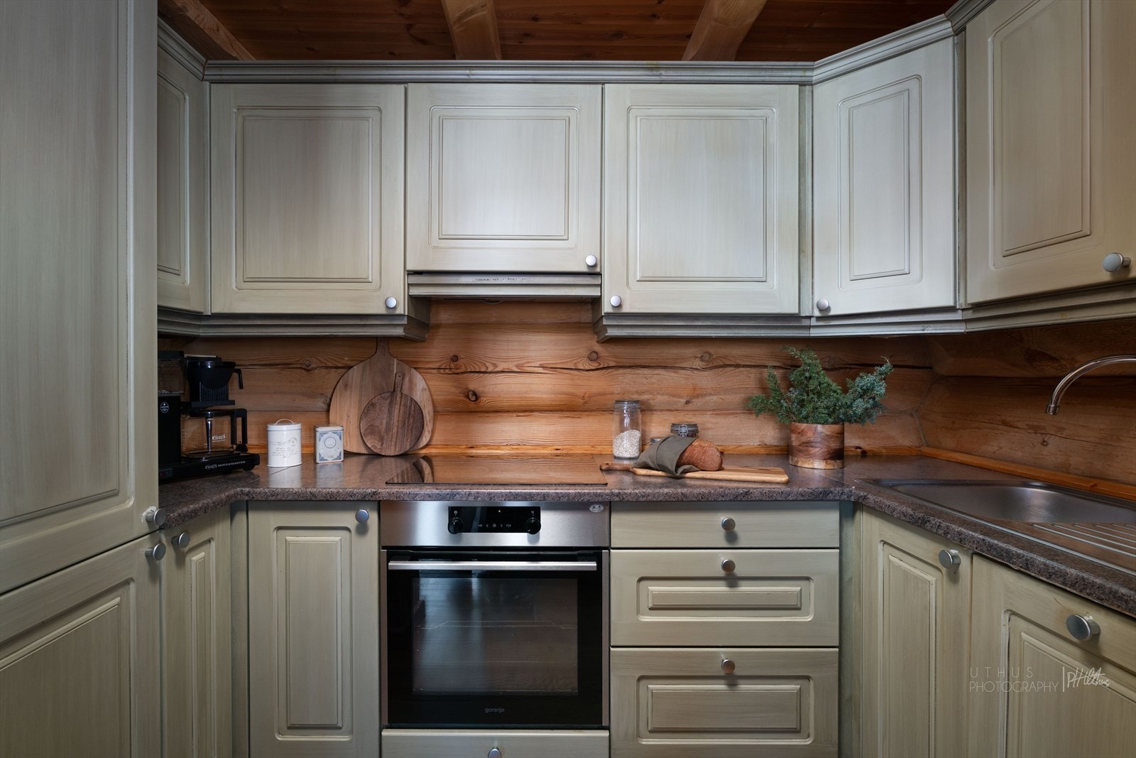 Kjøkkenet har innredning i heltre med profilerte fronter og laminert benkeplate Galleribilde