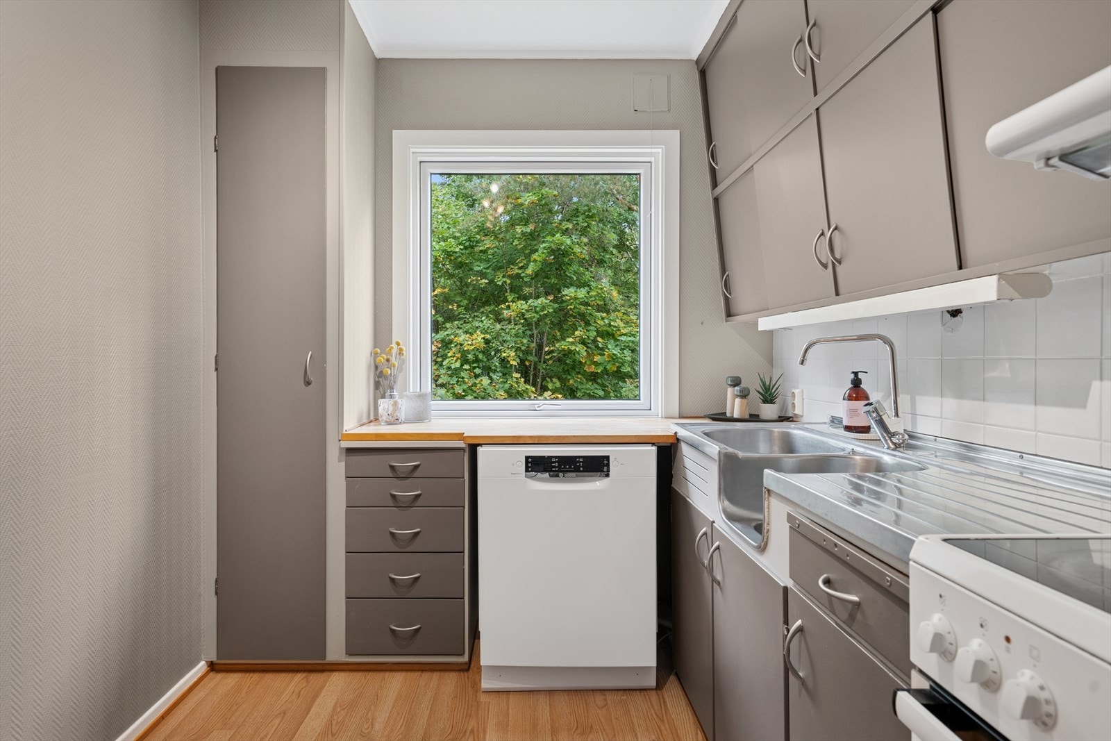 Innredningen har glatte fronter med benkeplate i heltre og i rustfritt stål med nedfelt oppvaskkum. Galleribilde