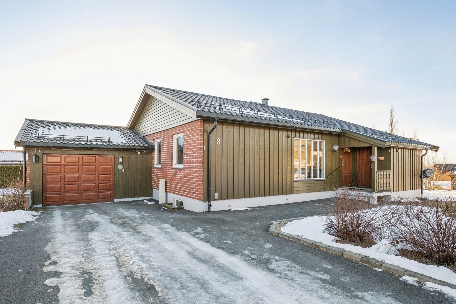 Pent opparbeidet tomt med asfaltert gårdsplass og stenlagte overganger. Galleribilde