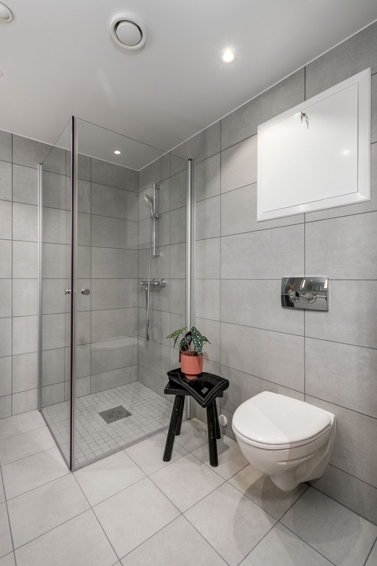 Badet har vegghengt toalett med innbygget sisterne, servant med skapinnredning samt speil med belysning. Galleribilde