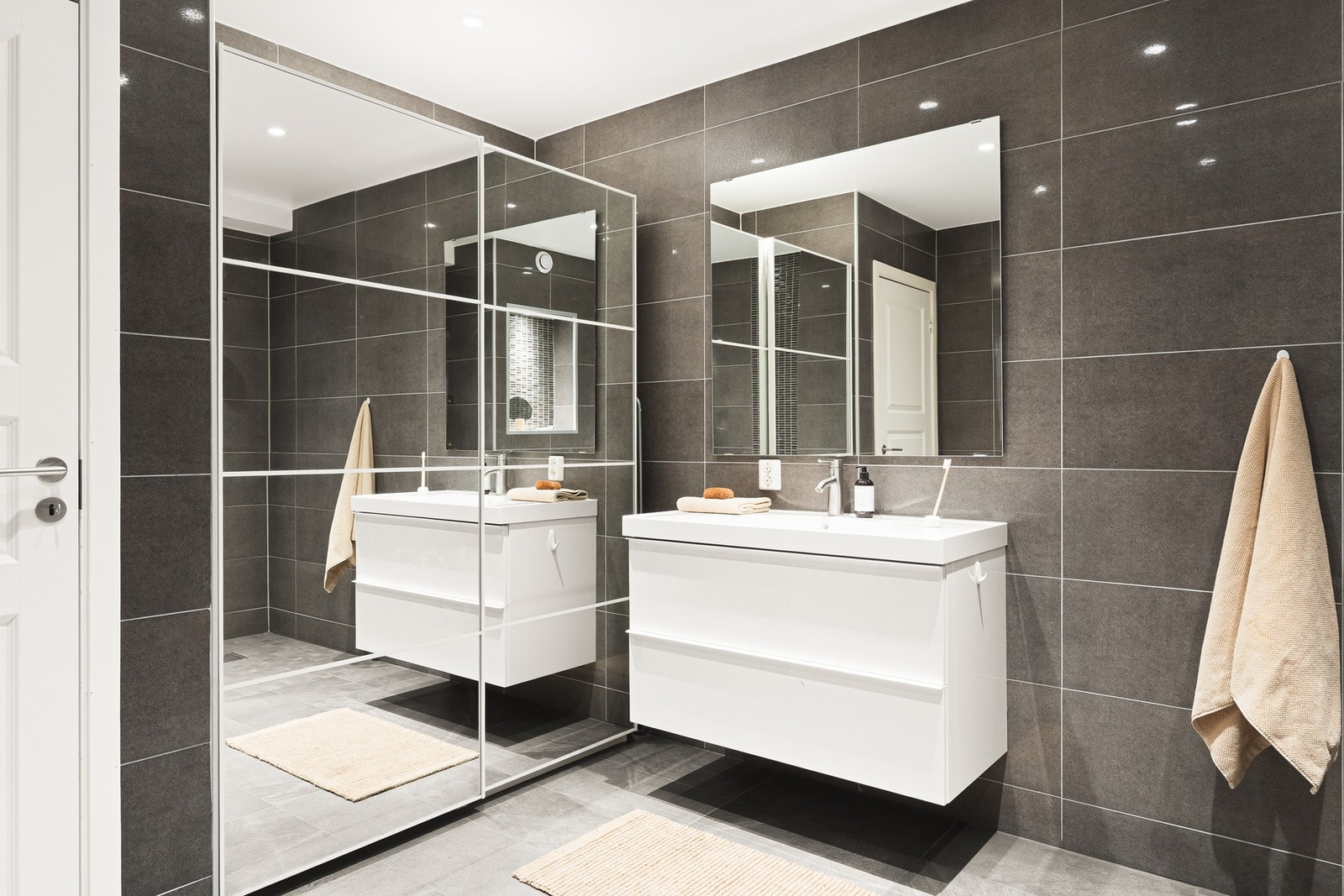 Badet er innredet med vegghengt toalett, servant med innredning, dusjhjørne og opplegg for vaskemaskin. Galleribilde