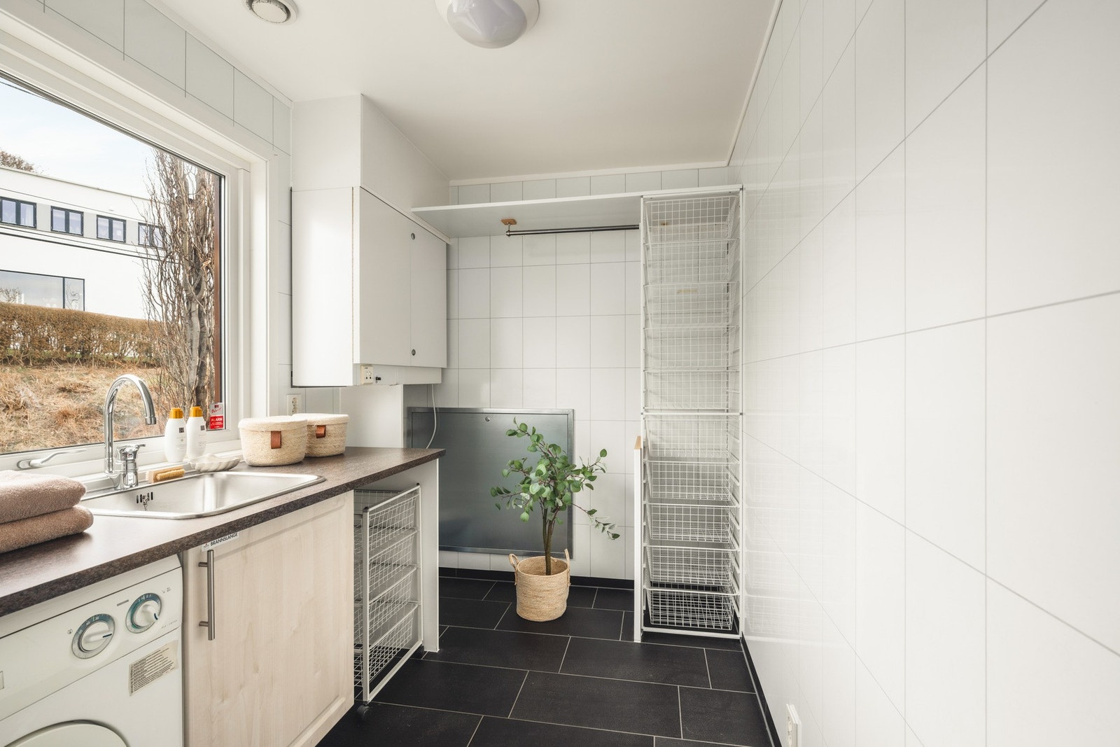 Praktisk vaskerom med fliser på gulv og vannbåren varme. Galleribilde